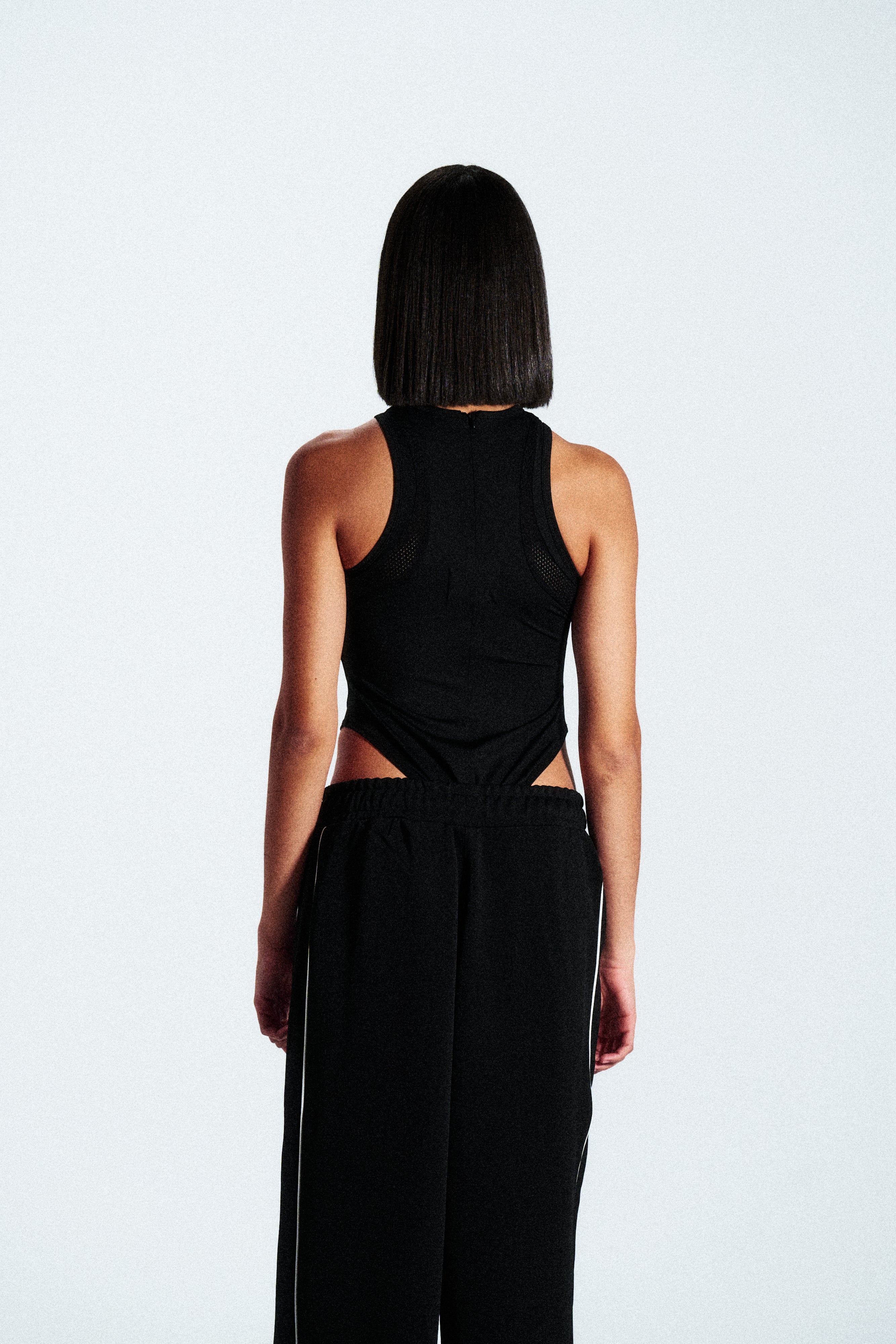Sleeveless shaping bodysuit made from stretch technical fabric. Available in black. Worldwide shipping.