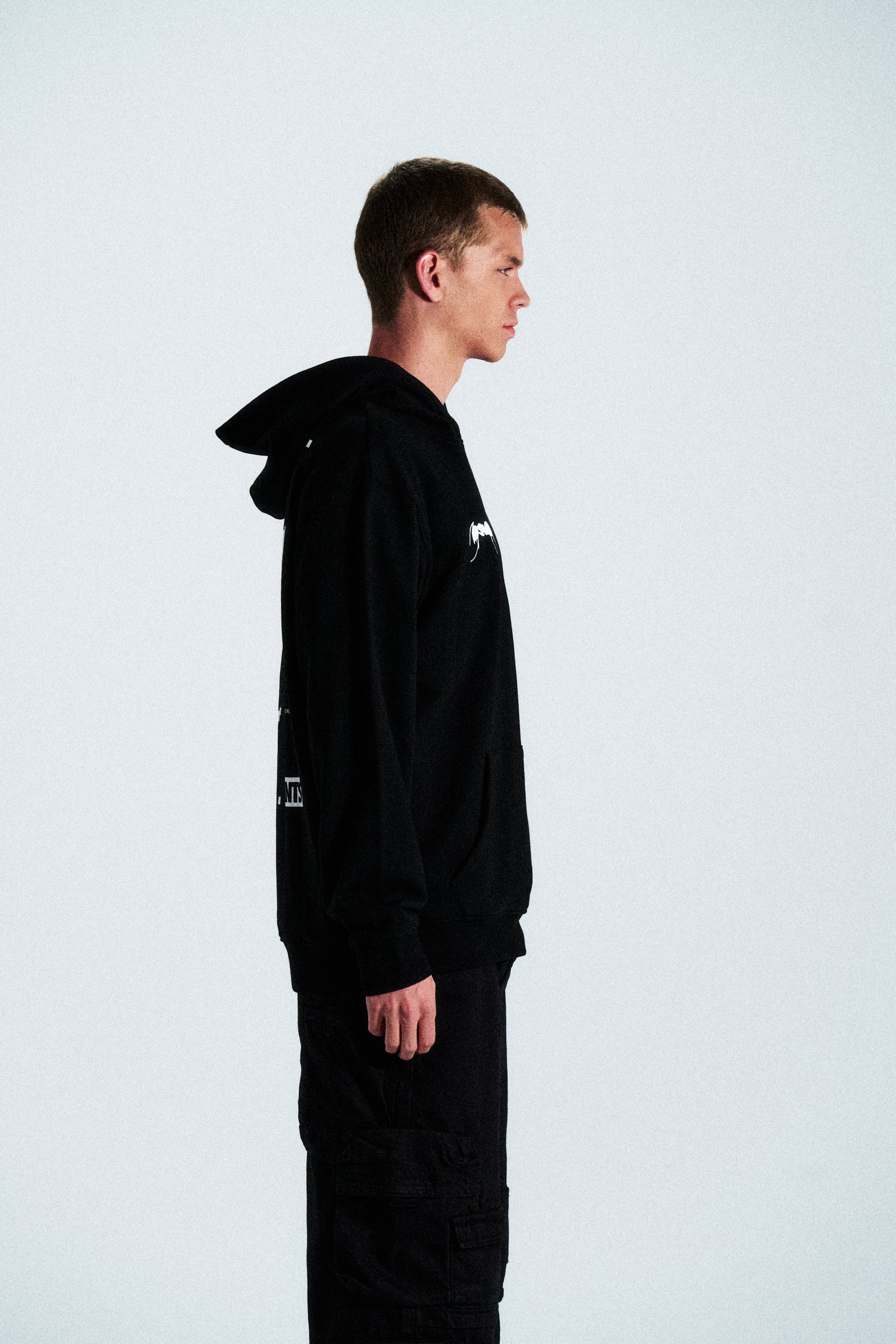 The Built Stronger Hoodie is crafted from French Terry Cotton. The black hoodie is emblazoned with a white ANTS logo on the front and features artwork on the back. A unique piece of merchandise and a versatile addition to any outfit.