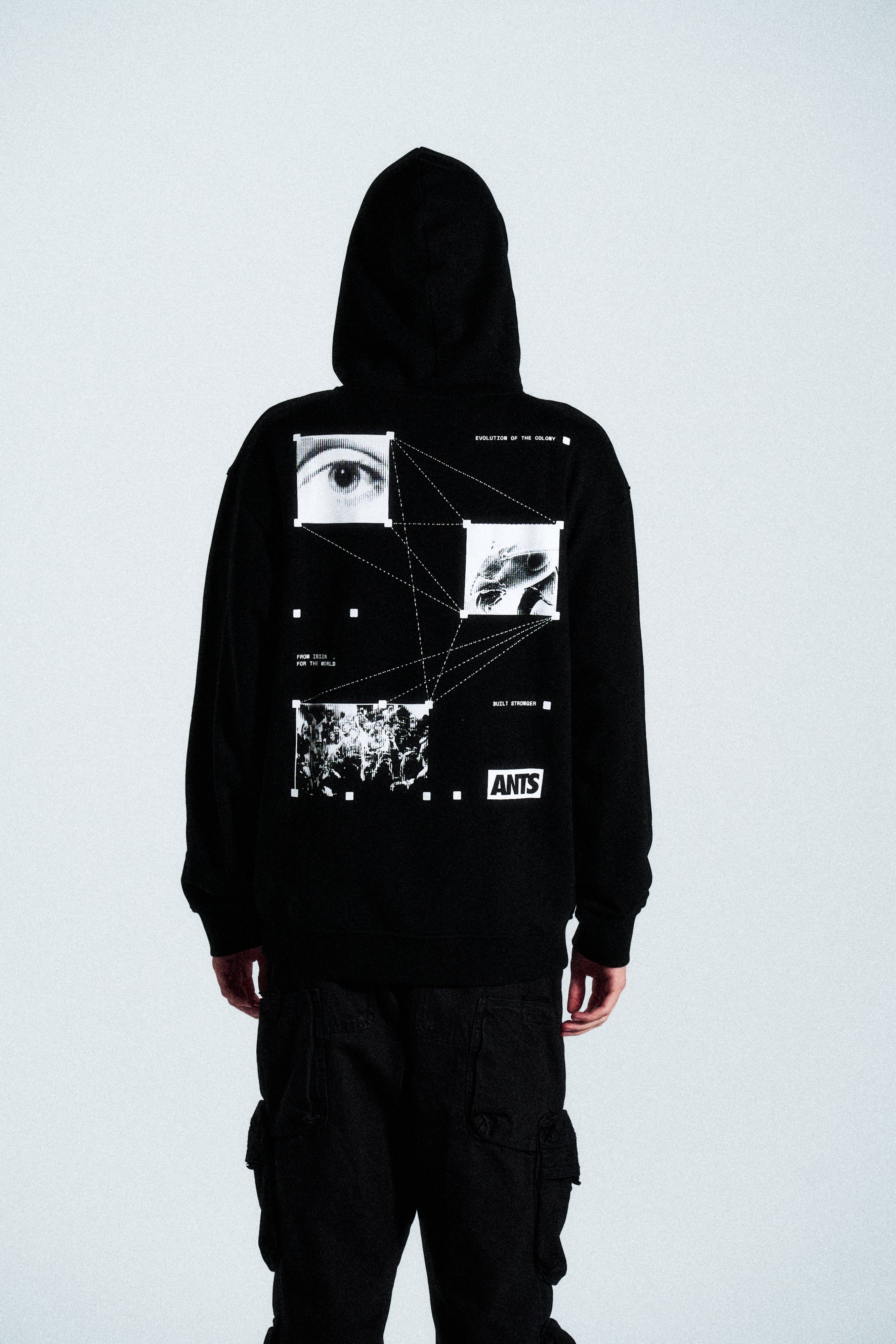 The Built Stronger Hoodie is crafted from French Terry Cotton. The black hoodie is emblazoned with a white ANTS logo on the front and features artwork on the back. A unique piece of merchandise and a versatile addition to any outfit.