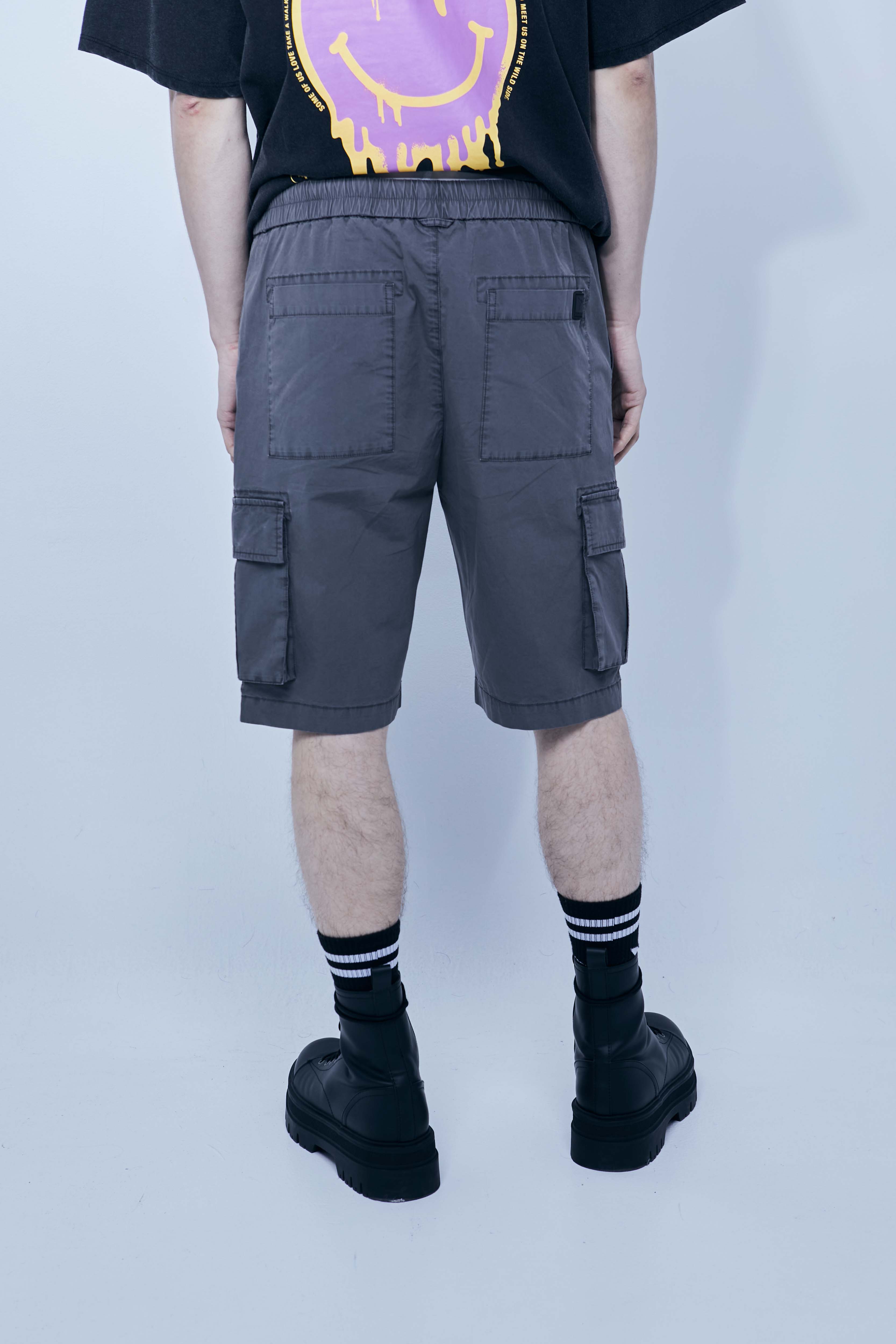 Cargo shorts made of a washed cotton blend with a fade out effect. Adjustable waistband with drawstring. Side and front cargo pockets. Rubberized patch detail on back patch pocket. Front zipper closure