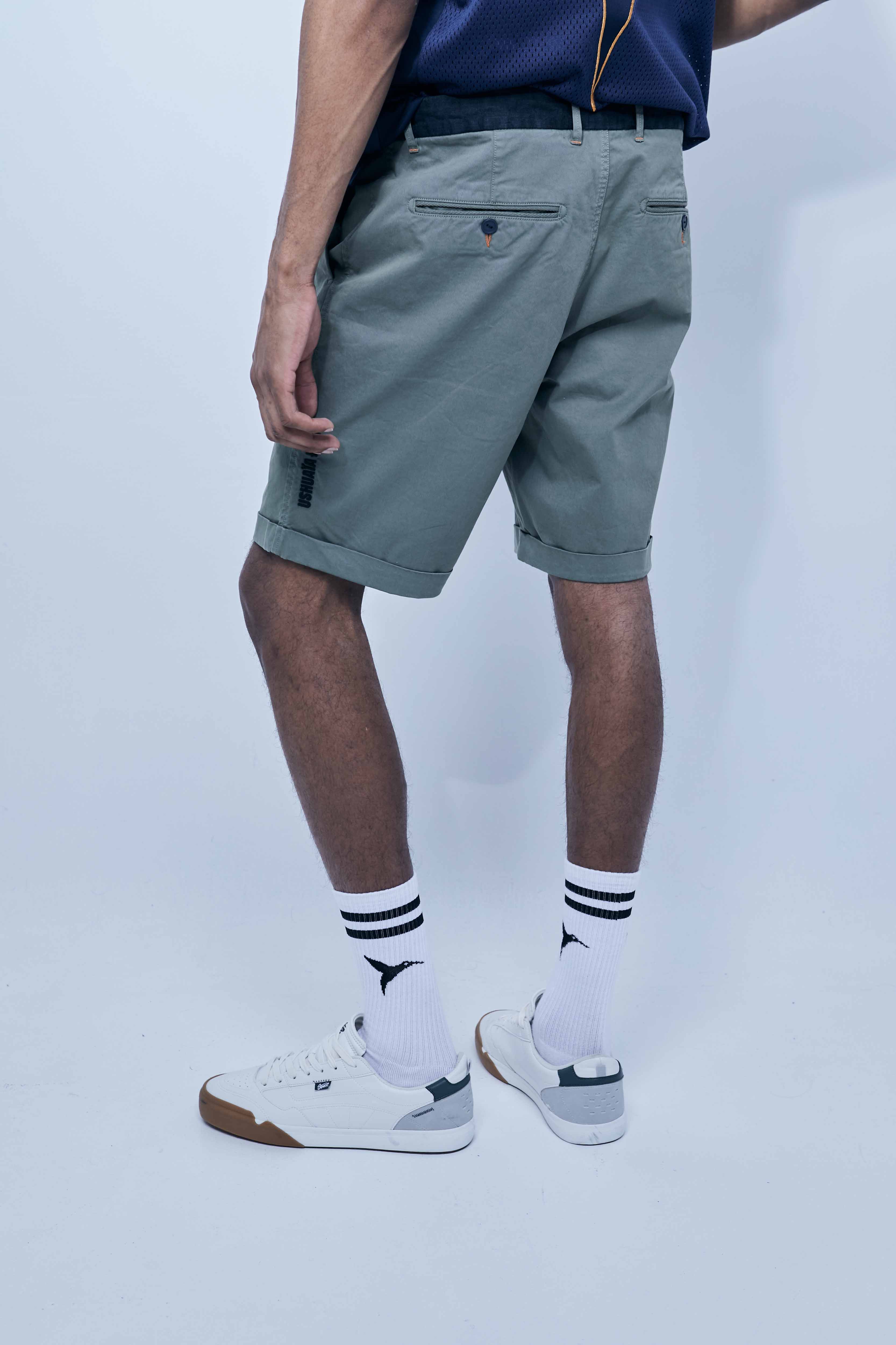Chino shorts made of cotton-blend fabric. Contrast embroidery on the front and side. Decorative stitching detail and contrast waistband. Front pockets and back welt pockets. Front zipper and button closure