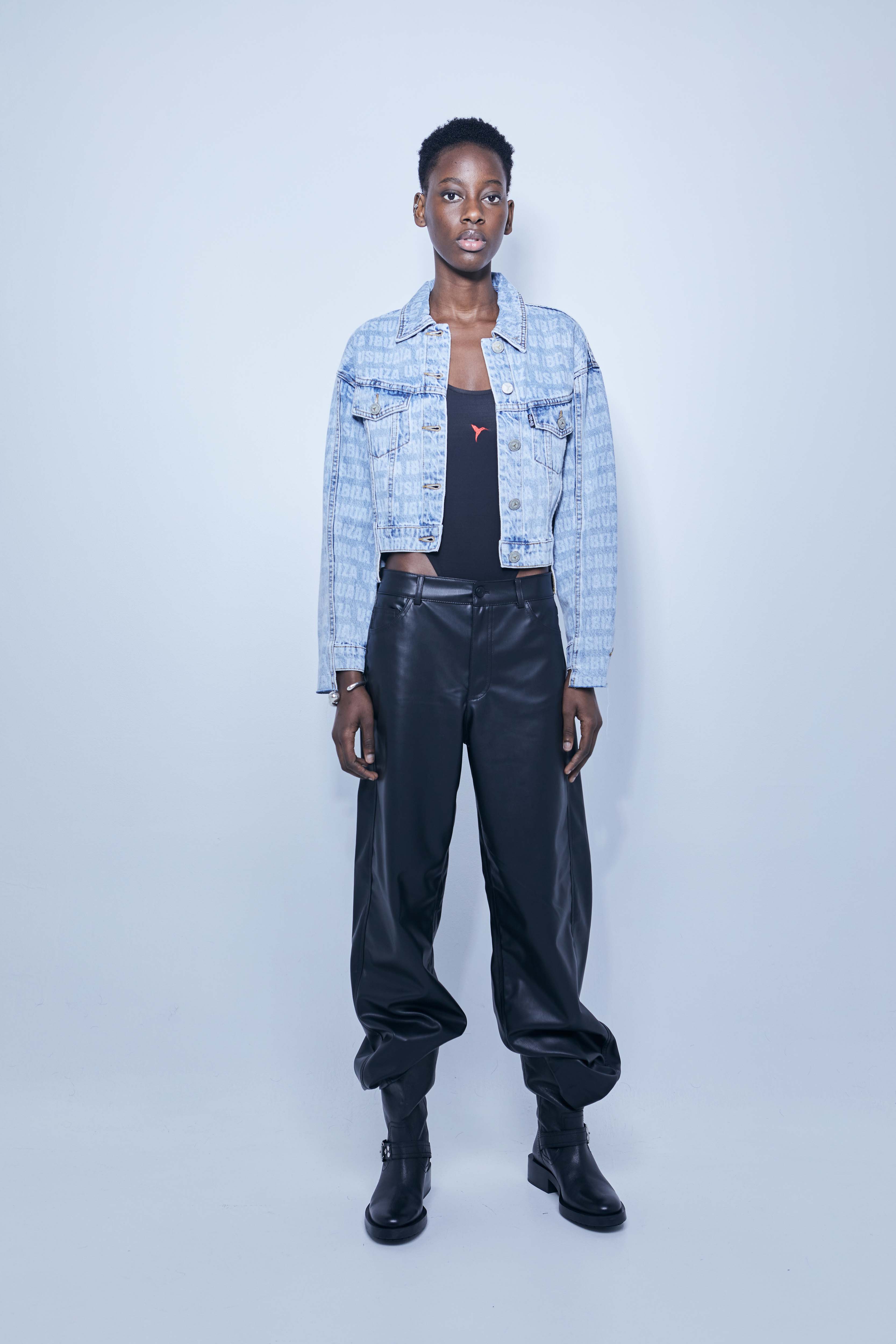 Jacket with lapel collar and long sleeves. Front pockets. Uneven hem with frayed ends. Laser print detail. Front closure with metal buttons.