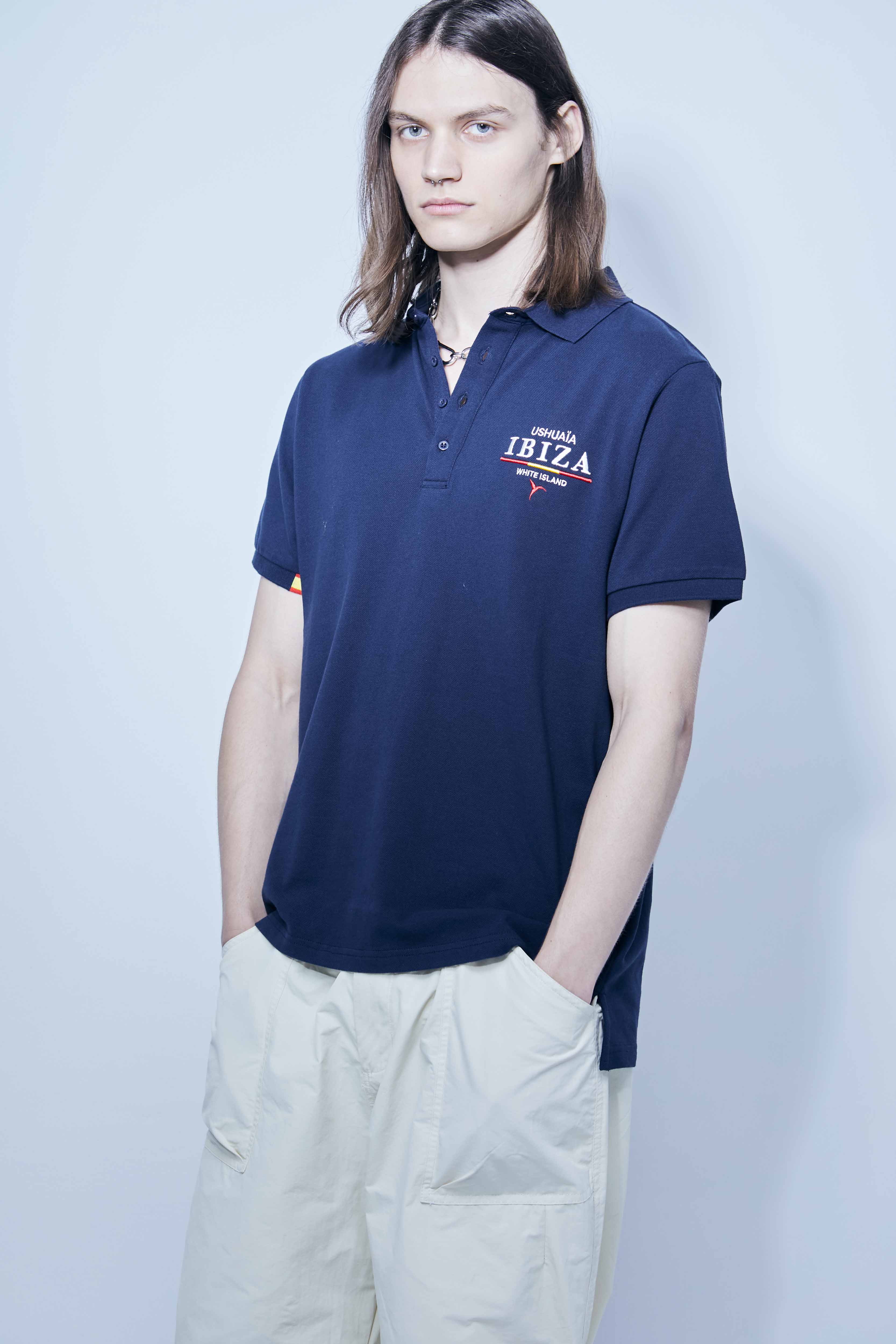 Polo made of cotton fabric with a mercerized finish. Lapel collar with front button closure and short sleeves. Embroidered application detail on the front