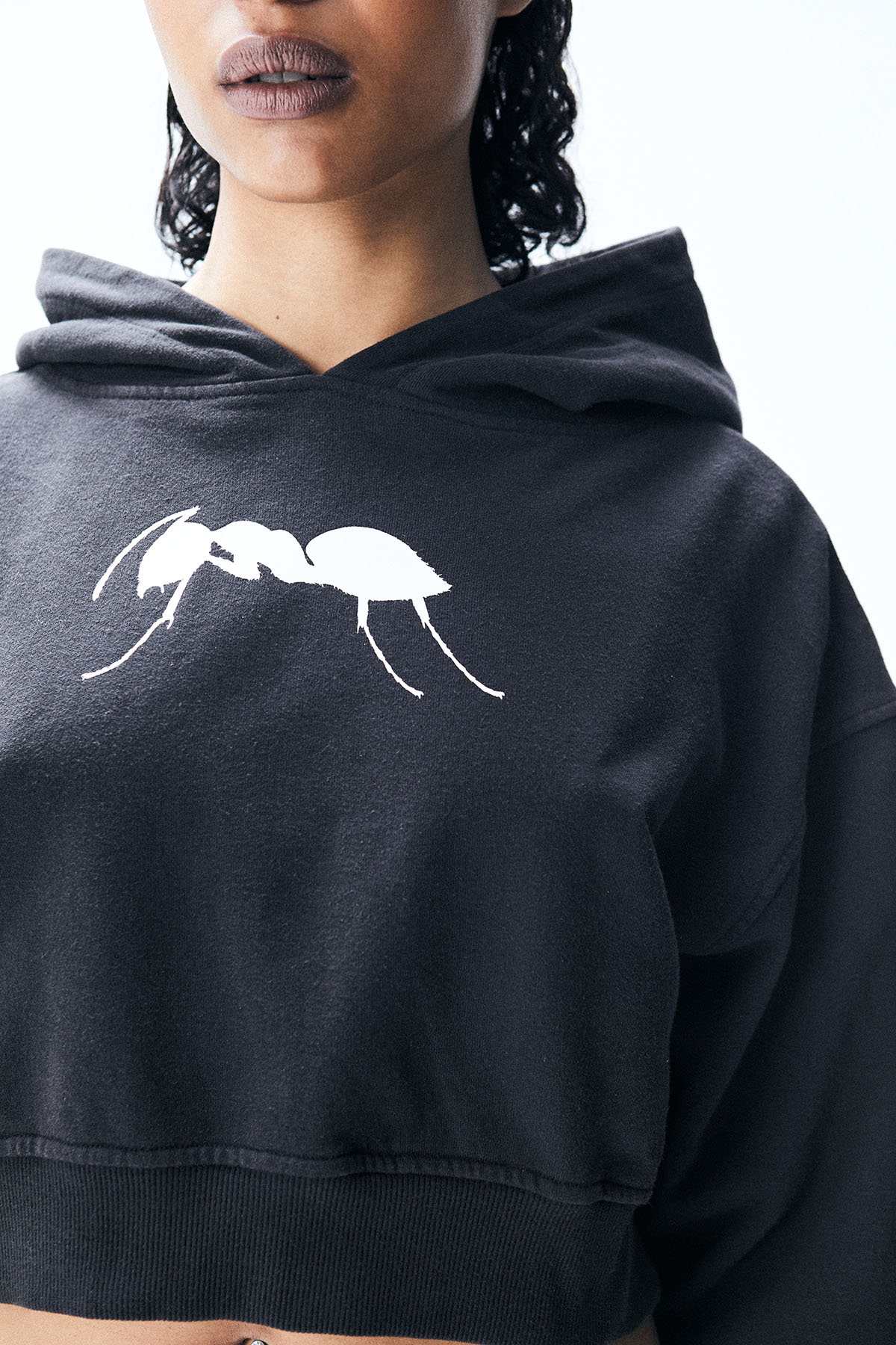 Cropped hoodie with long sleeves and faded wash effect. Front graphic print with contrasting details.