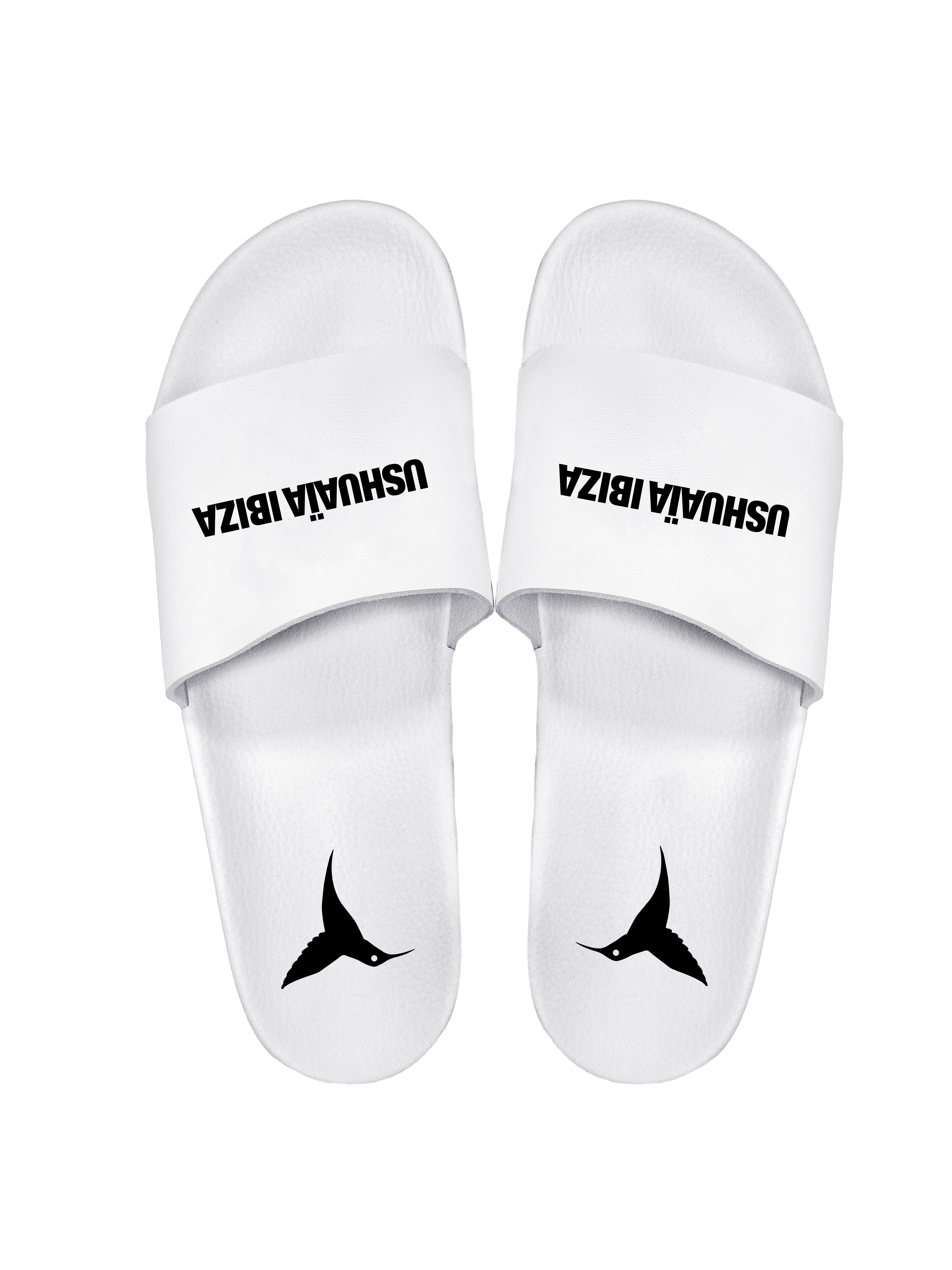 White flip flops with black logo.Polyurethane sole with cotton and polyester lining.Screen printing and engraving in high frecuency.