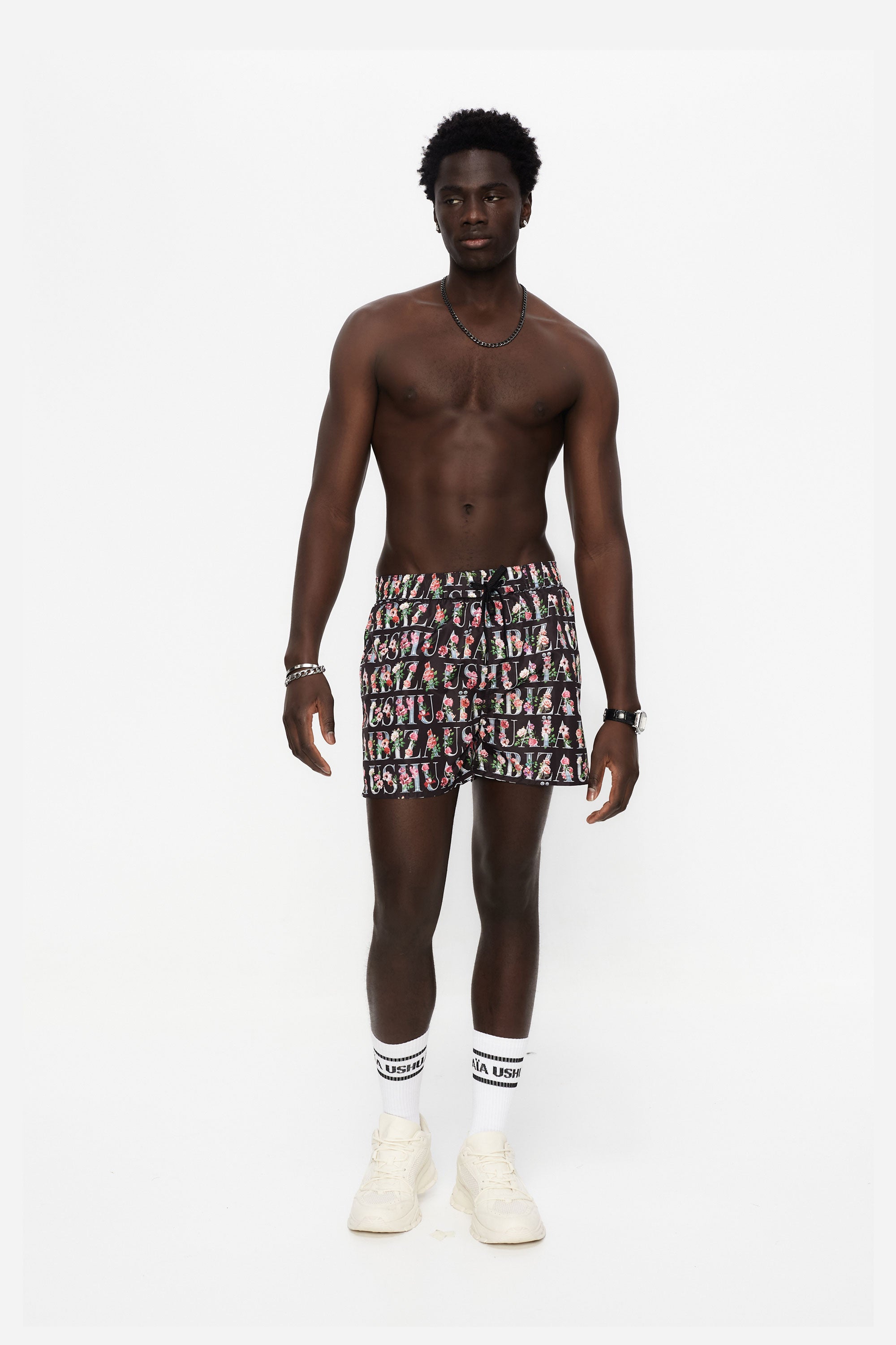 Swimsuit made of technical fabric. Adjustable elastic waistband with drawstring. Side pockets, rubberized application detail on the front and patch pocket on the back. Inner lining.