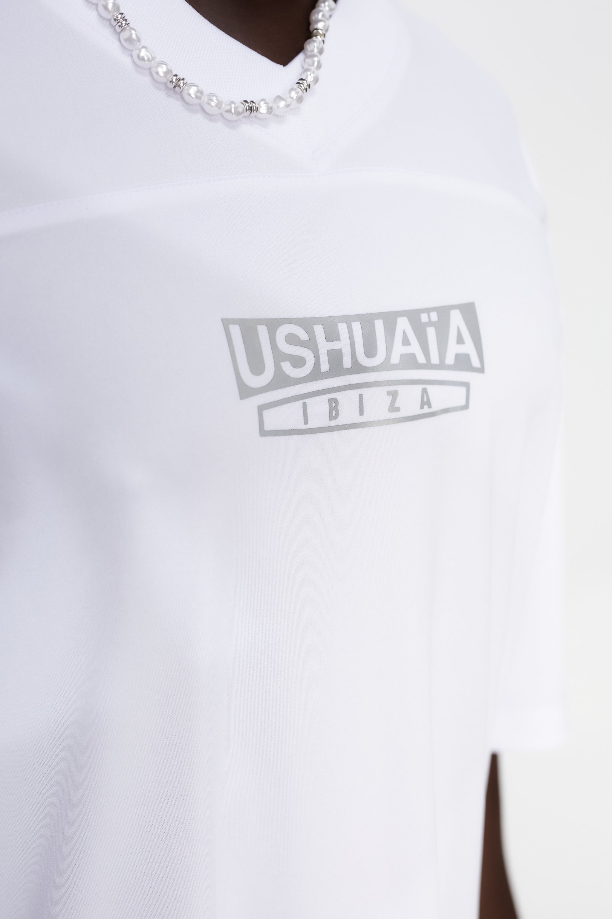 Combined rugby style t-shirt made of technical fabric and mesh, light and breathable. V-neck and short sleeves. Combined reflective print detail on front and back.