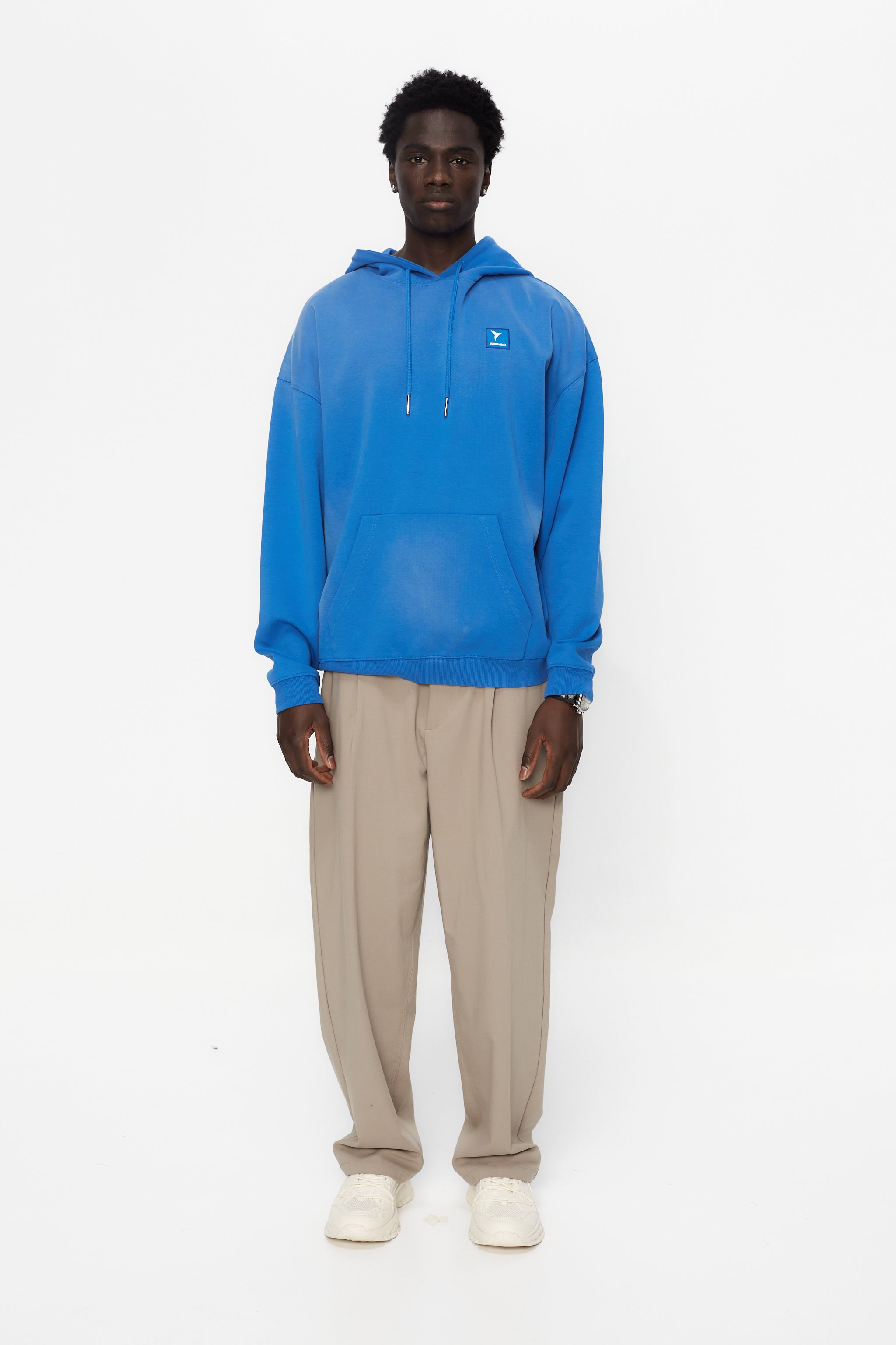 Oversized sweatshirt with adjustable hood with drawstring and long sleeves washed with enzymatic effect. Contrast combined patch detail on the front and print on the back. Kangaroo pocket on the front. Ribbed finishes.