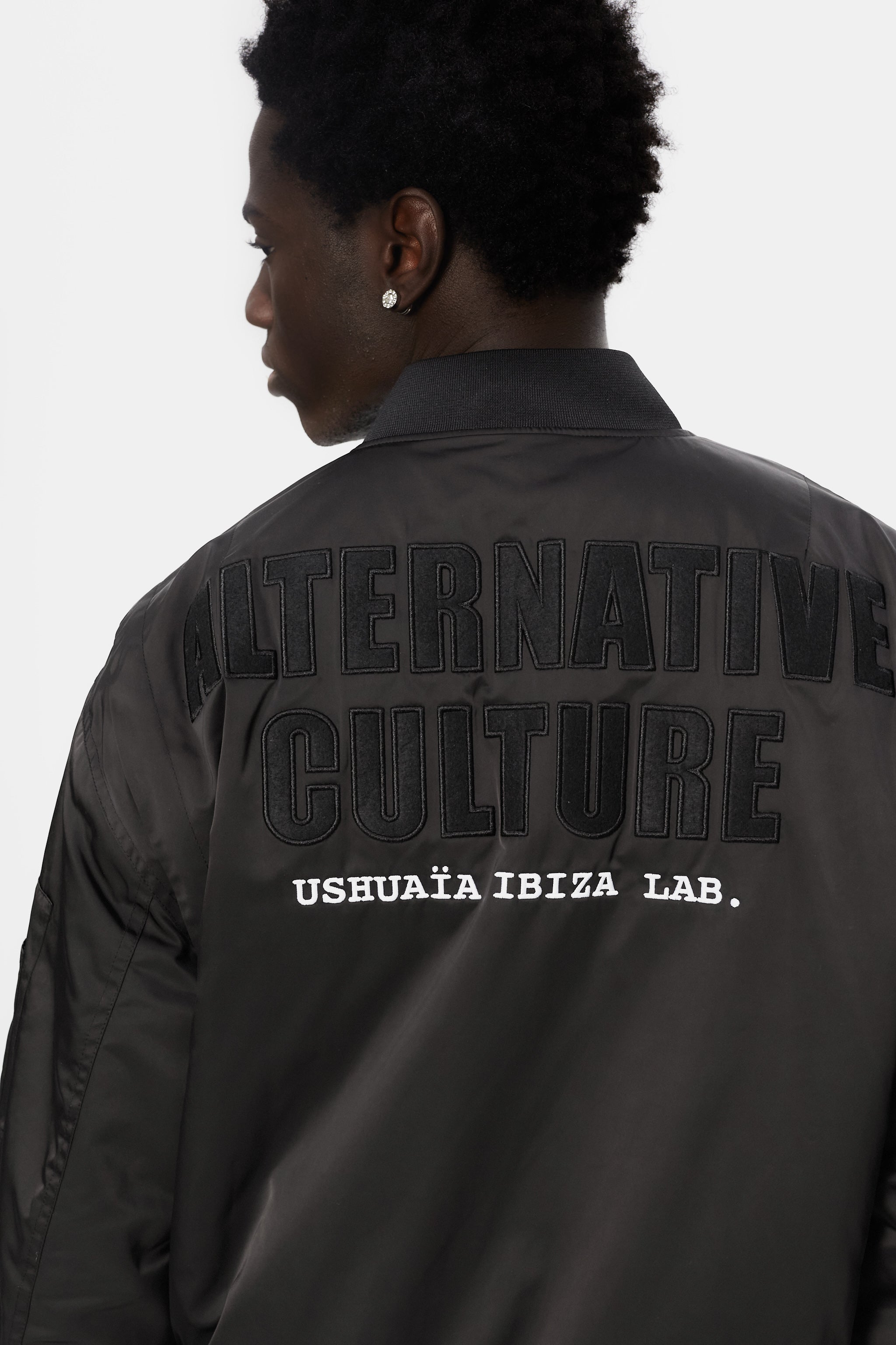 Satin bomber jacket with elastic collar and long sleeves. Rubber print detail on the front and fabric and embroidery application on the back. Front welt pockets. Sleeve pocket with custom puller. Front closure with two-way zipper. Ribbed finishes.