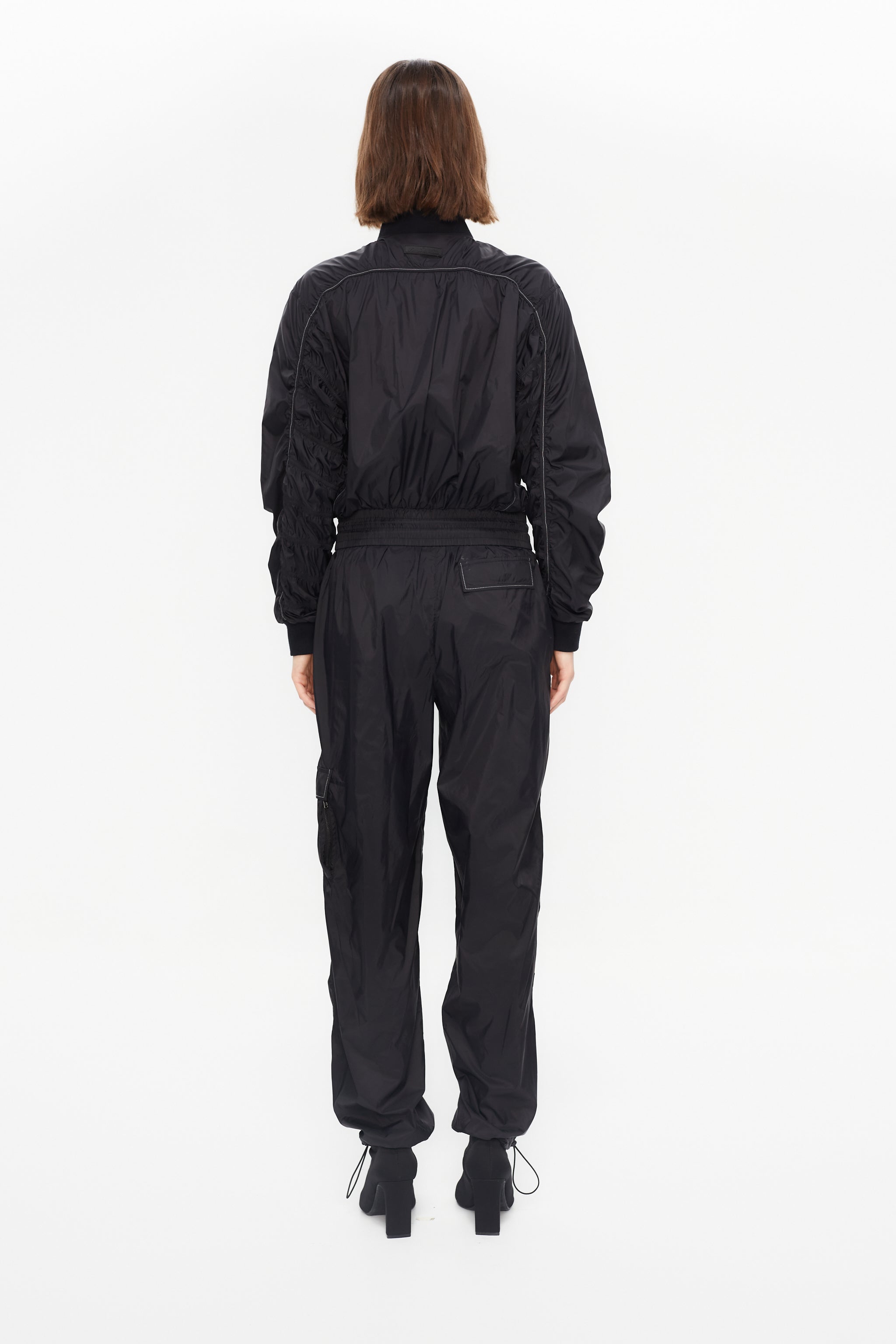 satin-effect cargo pants. Adjustable waistband with technical strap and metal buckle. Side cargo pockets and adjustable hems with elastic drawcord