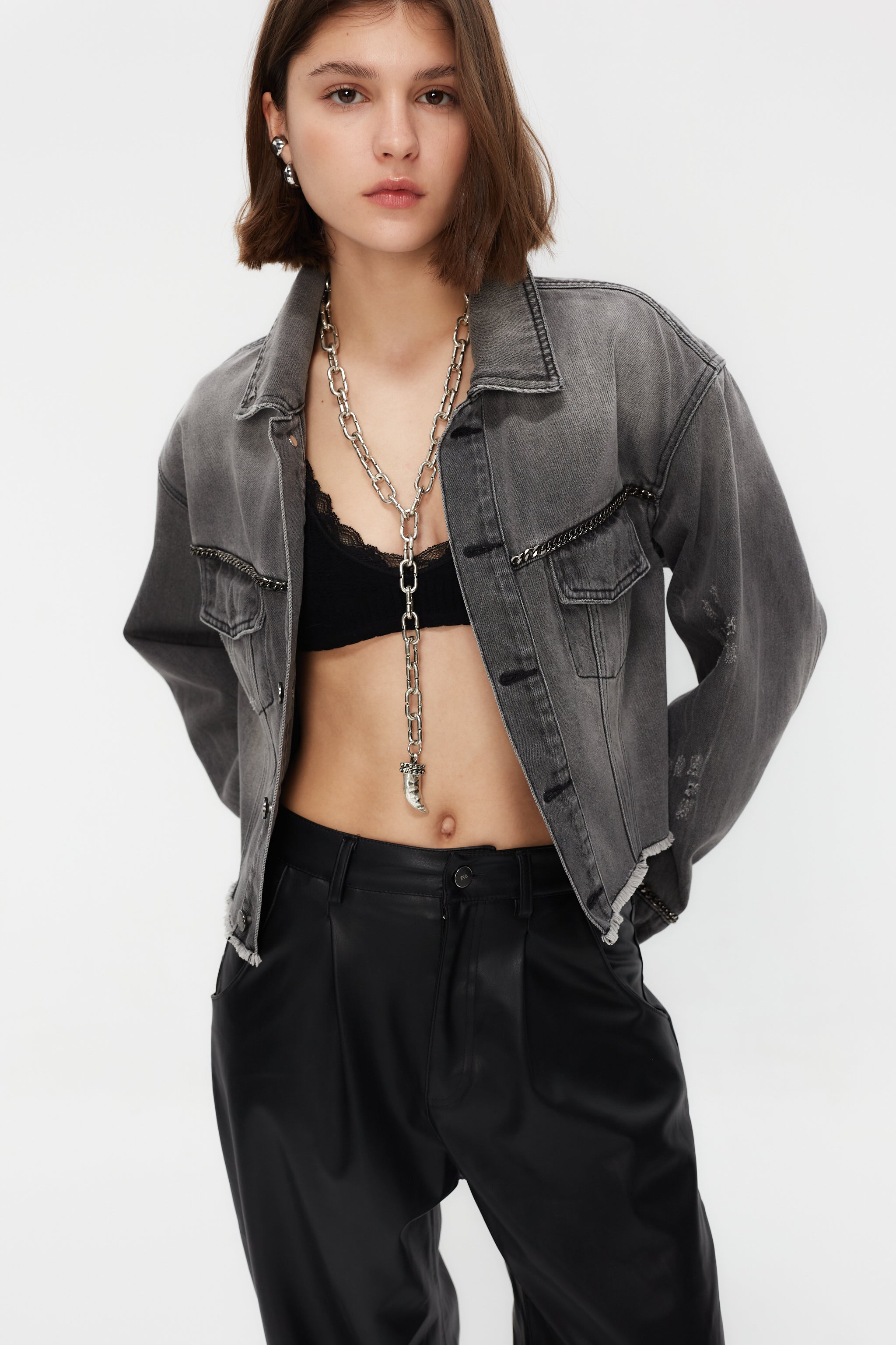Cropped denim jacket with lapel collar and long washed sleeves with fade out effect. Front closure with metallic buttons. Chain detail on the front and cuffs and contrast combined rhinestone print on the back.