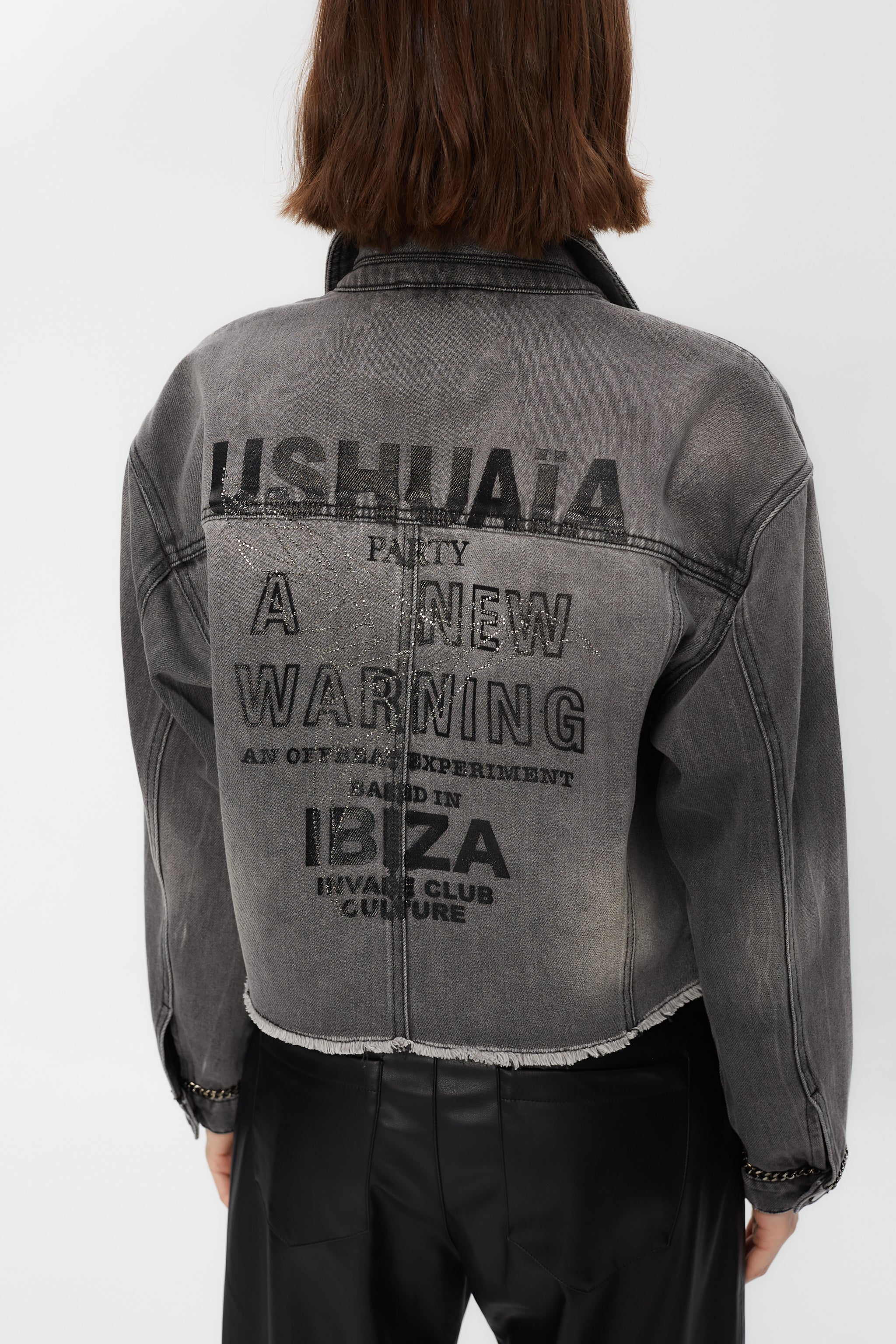 Cropped denim jacket with lapel collar and long washed sleeves with fade out effect. Front closure with metallic buttons. Chain detail on the front and cuffs and contrast combined rhinestone print on the back.