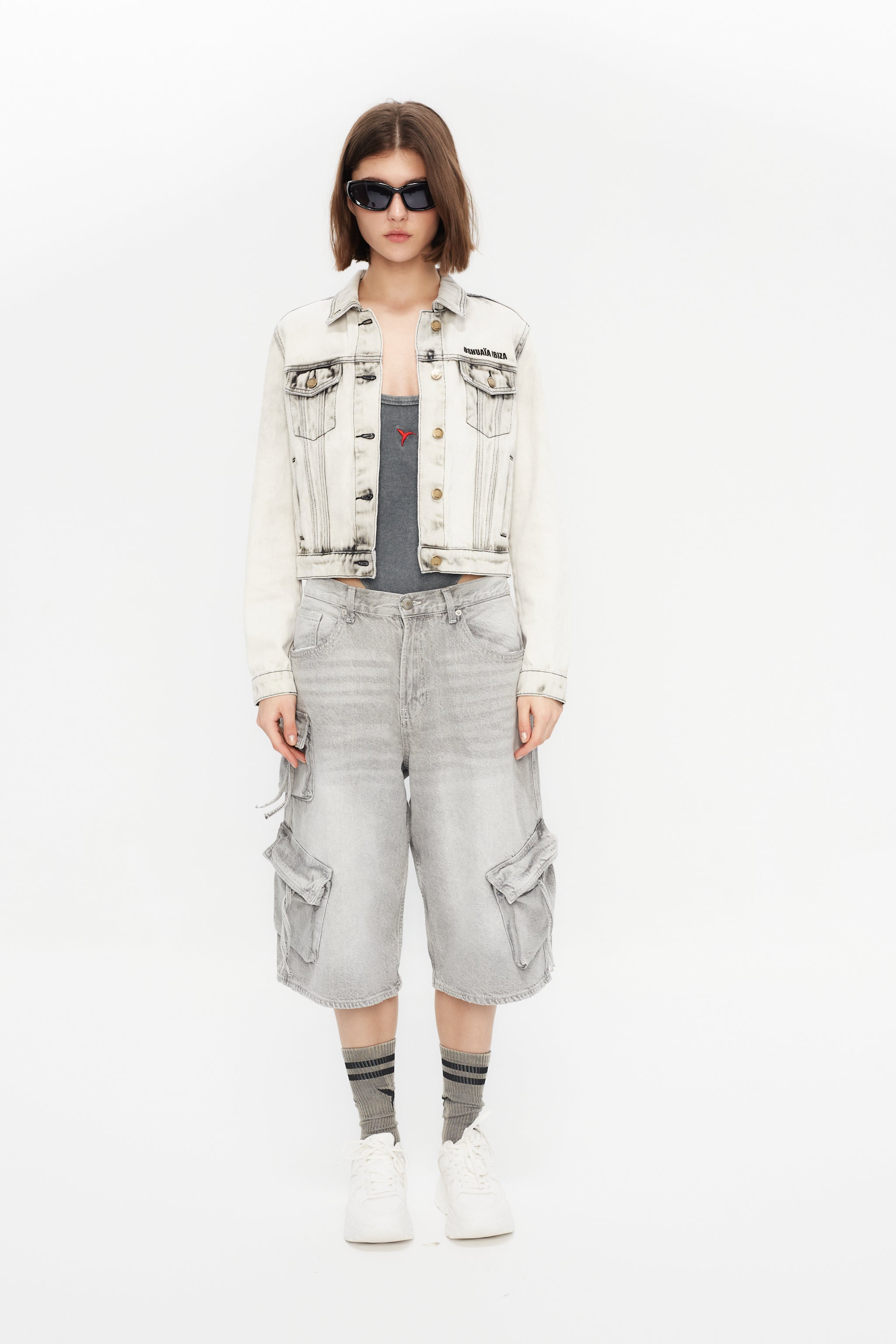 Cropped denim jacket with lapel collar and long sleeves, washed with a fade-out effect. Front closure with metal buttons. Features embroidery detail on the front and contrast combined print on the back.