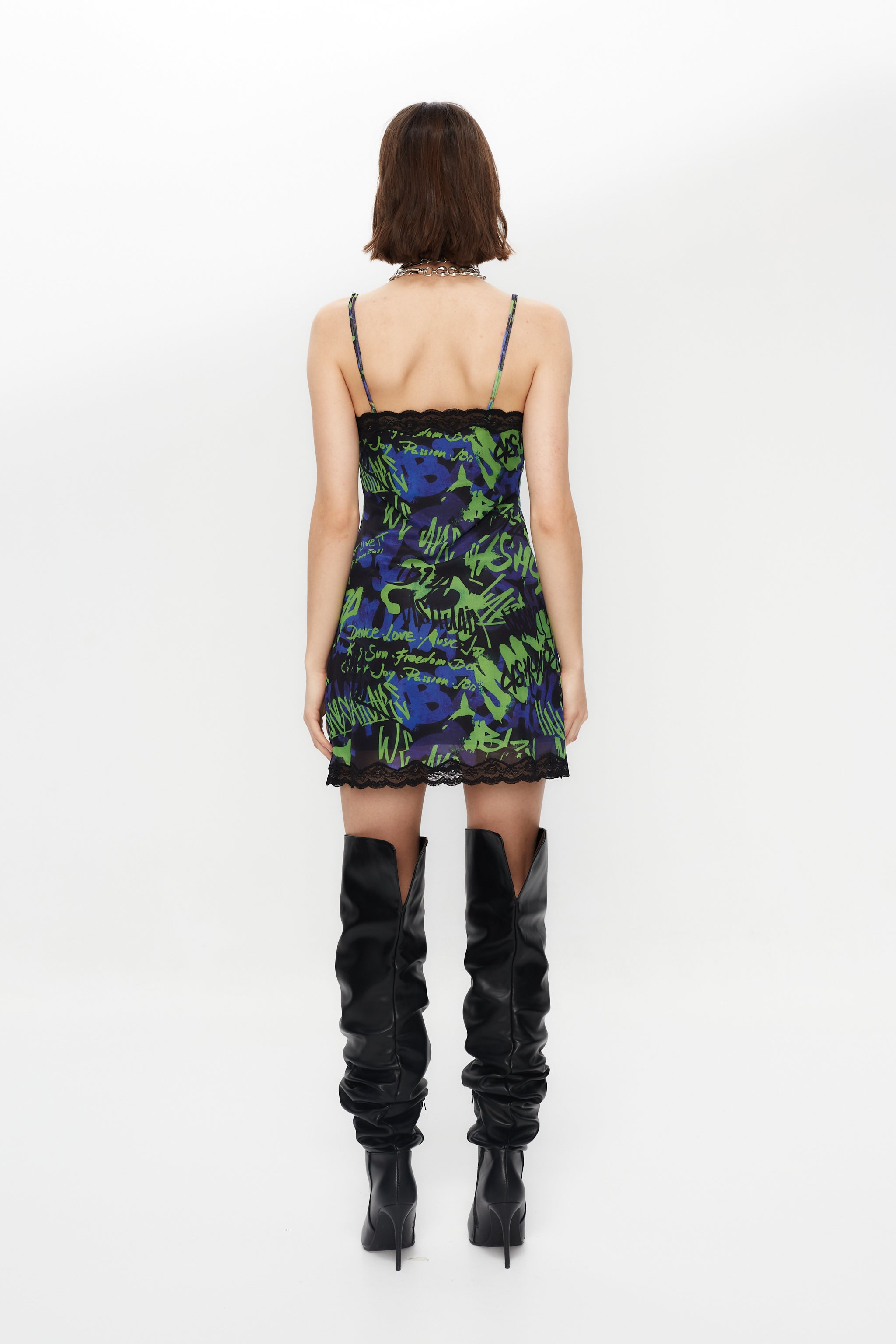 Elastic printed lingerie dress with lining. Adjustable straps. Lace and bow detail with metallic ornament on neckline and hem opening.