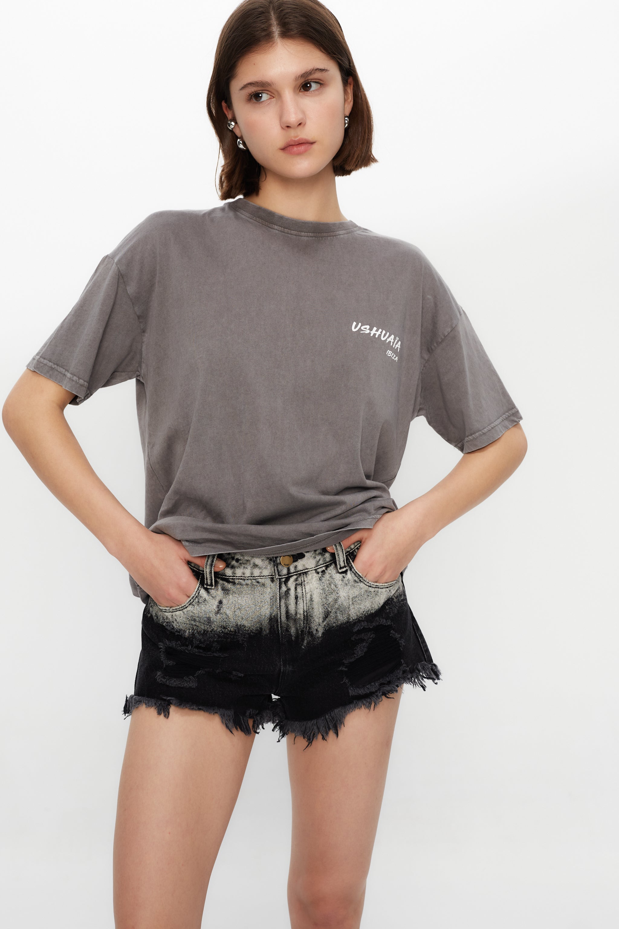 Denim shorts with tie-dye washed pockets. Label detail on the back. Frayed finish. Front closure with zipper and metallic button