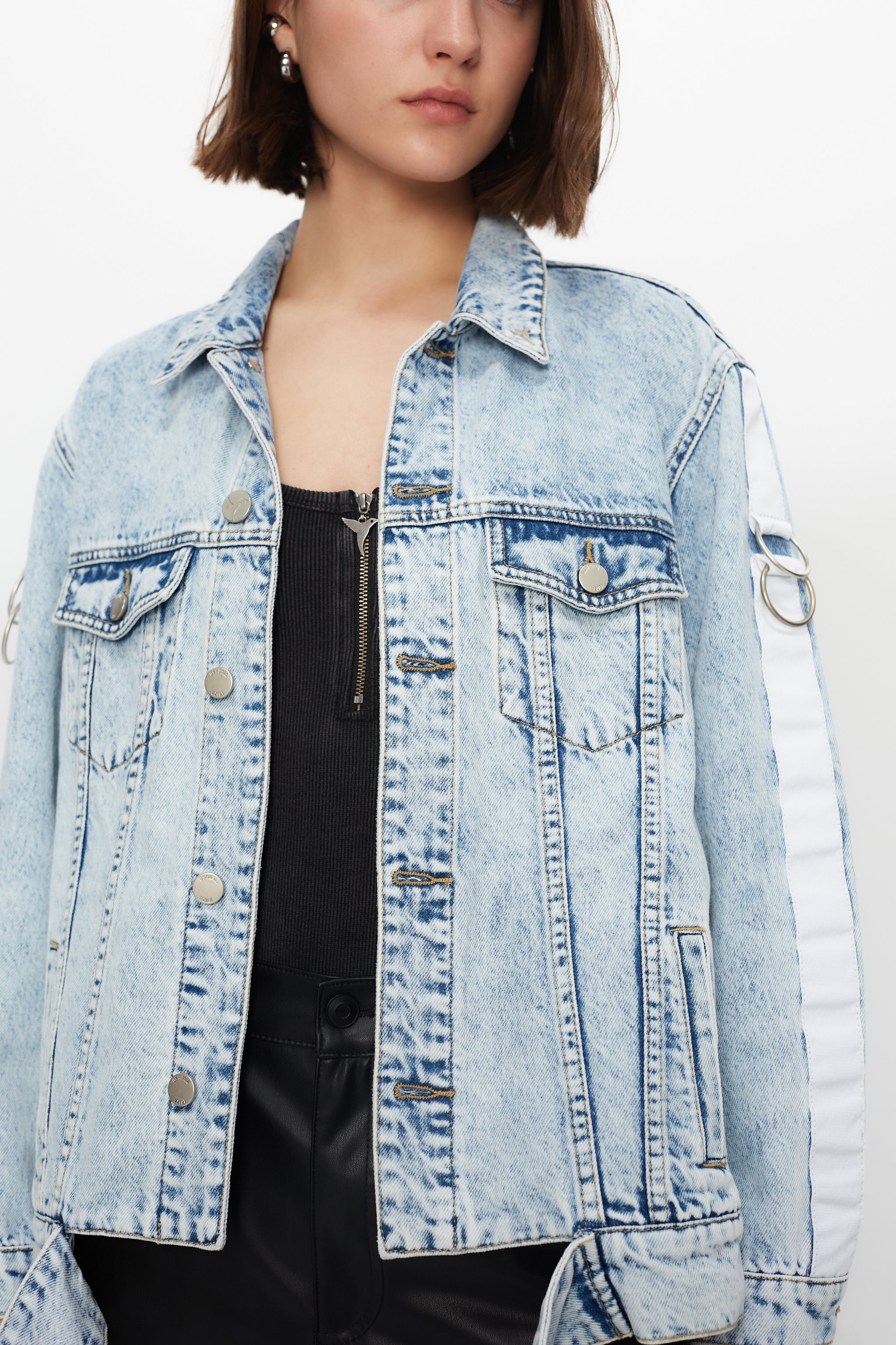 Denim jacket with a back panel featuring an appliqué with applied text and embroidery. Side sleeve panel embroidered with silver eyelet finish.