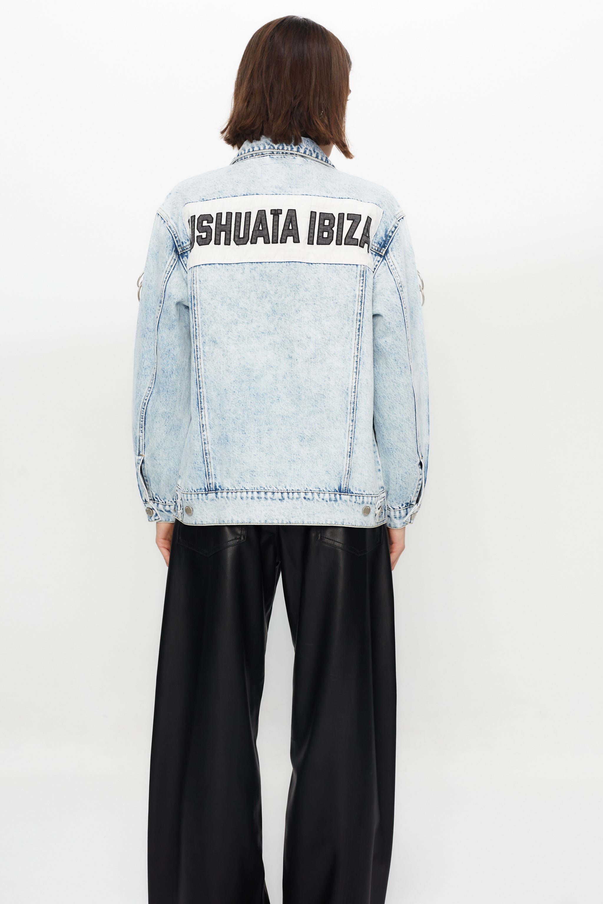 Denim jacket with a back panel featuring an appliqué with applied text and embroidery. Side sleeve panel embroidered with silver eyelet finish.