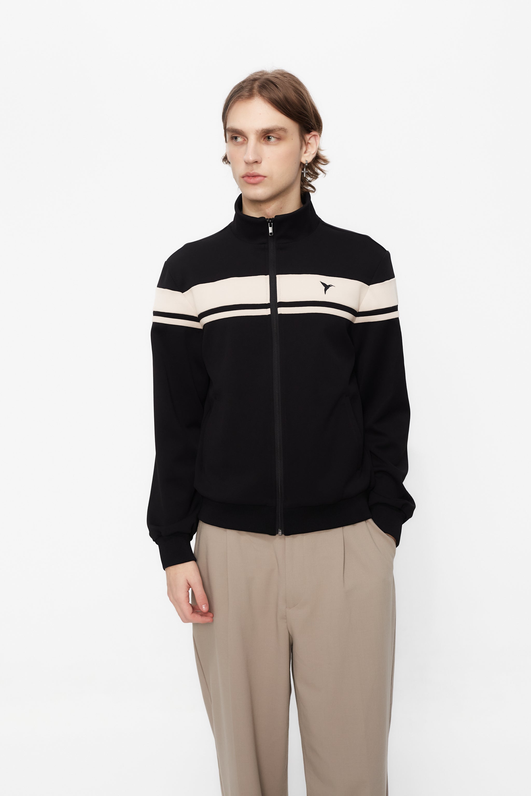 Sports jacket with mandarin collar and central zipper. Contrast combined embroidery detail on the back. Front welt pockets. Ribbed finishes.