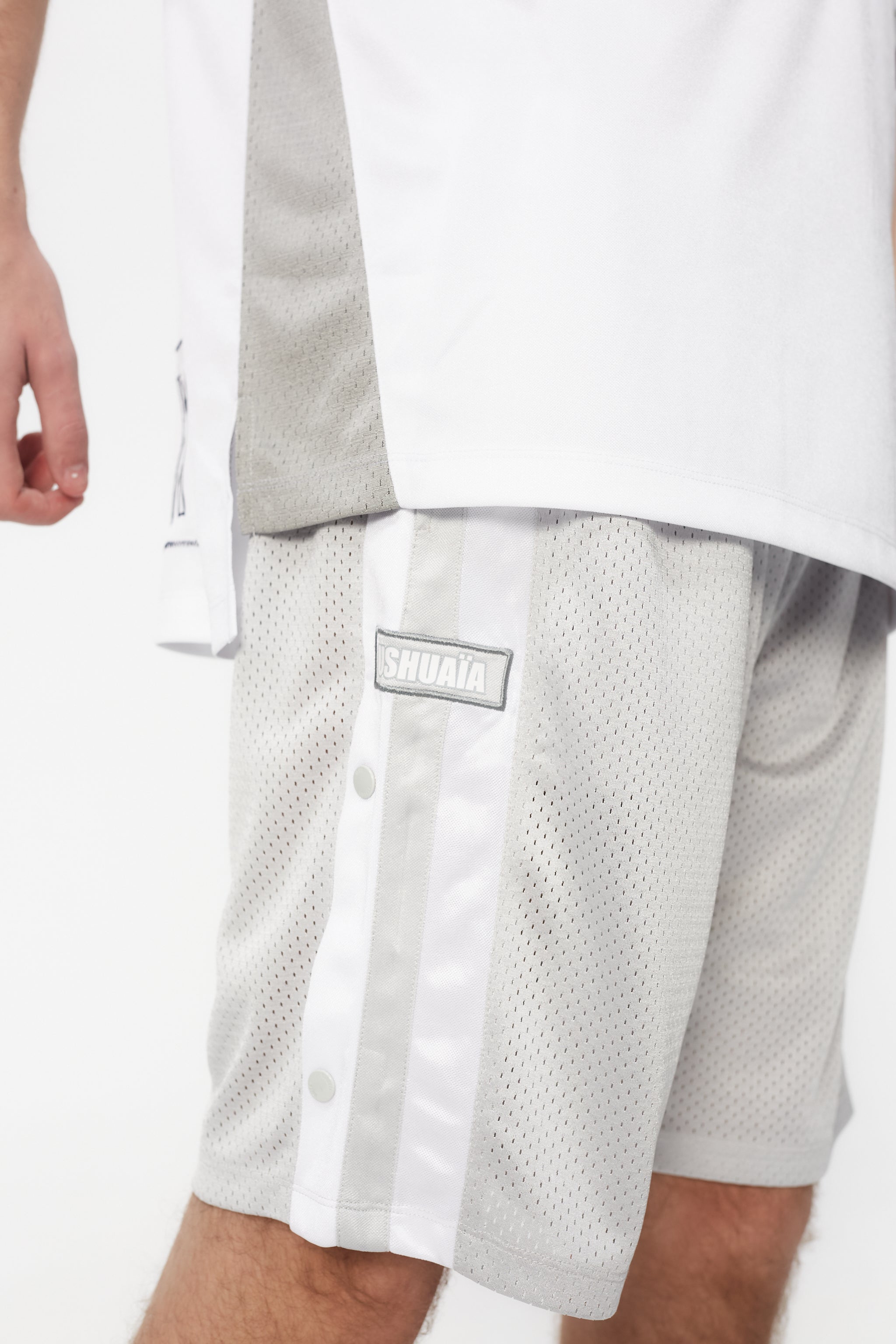 Bermuda shorts made of mesh fabric, light and breathable. Adjustable elastic waist with inner drawstring. Contrasting combined print on the front and side embroidery. Decorative snap detail on the sides with integrated pockets