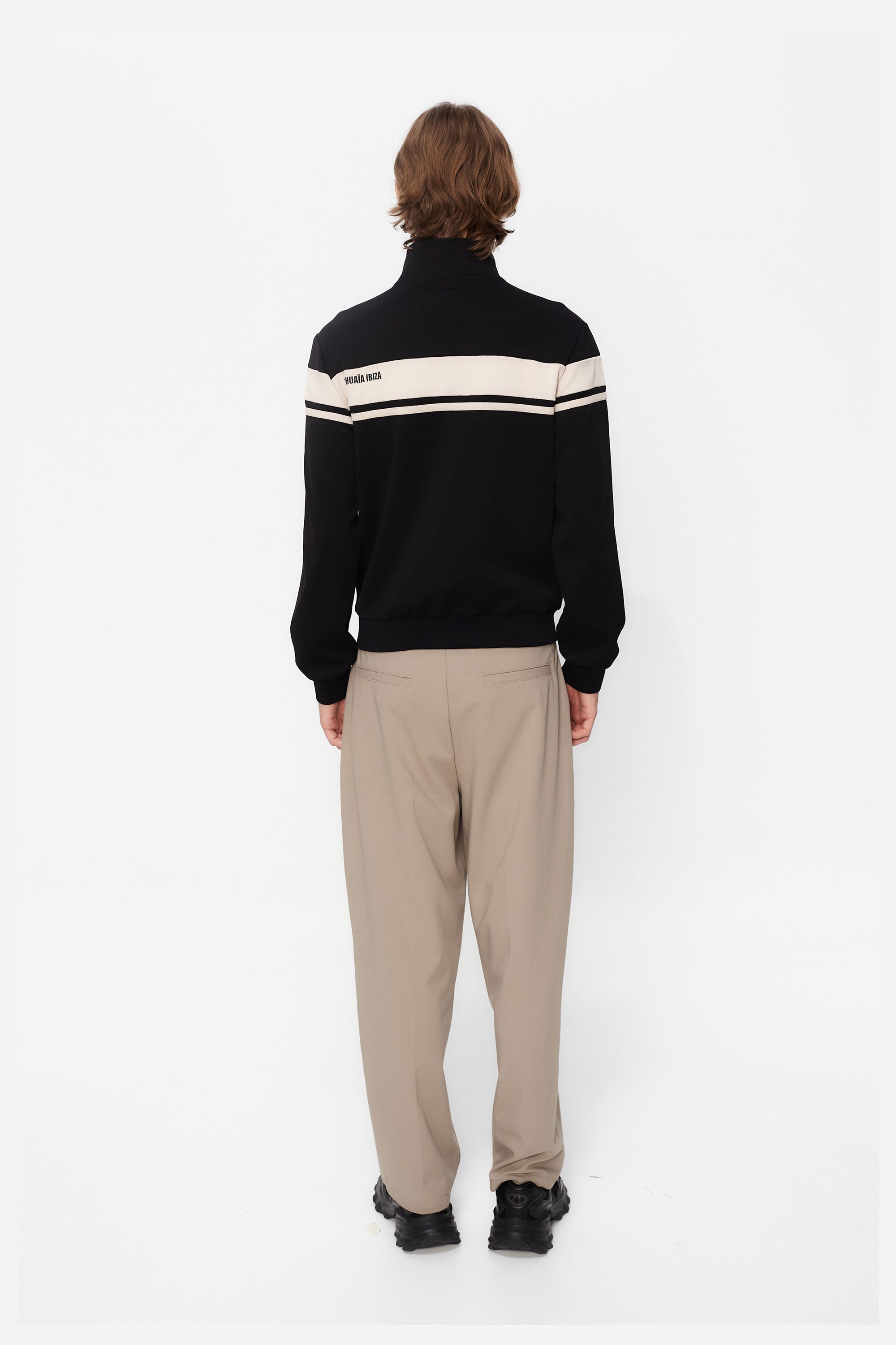 Sports jacket with mandarin collar and central zipper. Contrast combined embroidery detail on the back. Front welt pockets. Ribbed finishes.