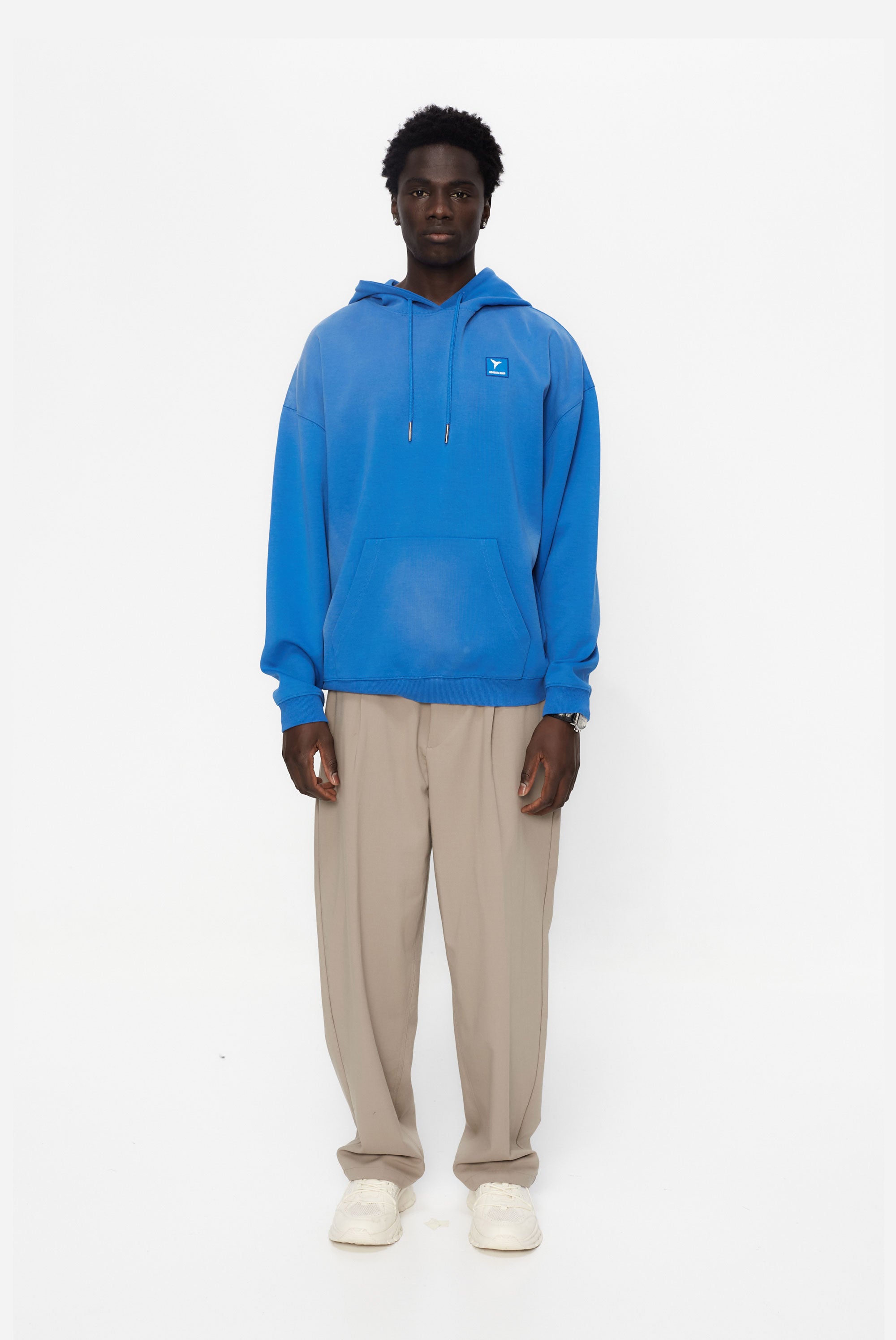 Oversized sweatshirt with adjustable hood with drawstring and long sleeves washed with enzymatic effect. Contrast combined patch detail on the front and print on the back. Kangaroo pocket on the front. Ribbed finishes.