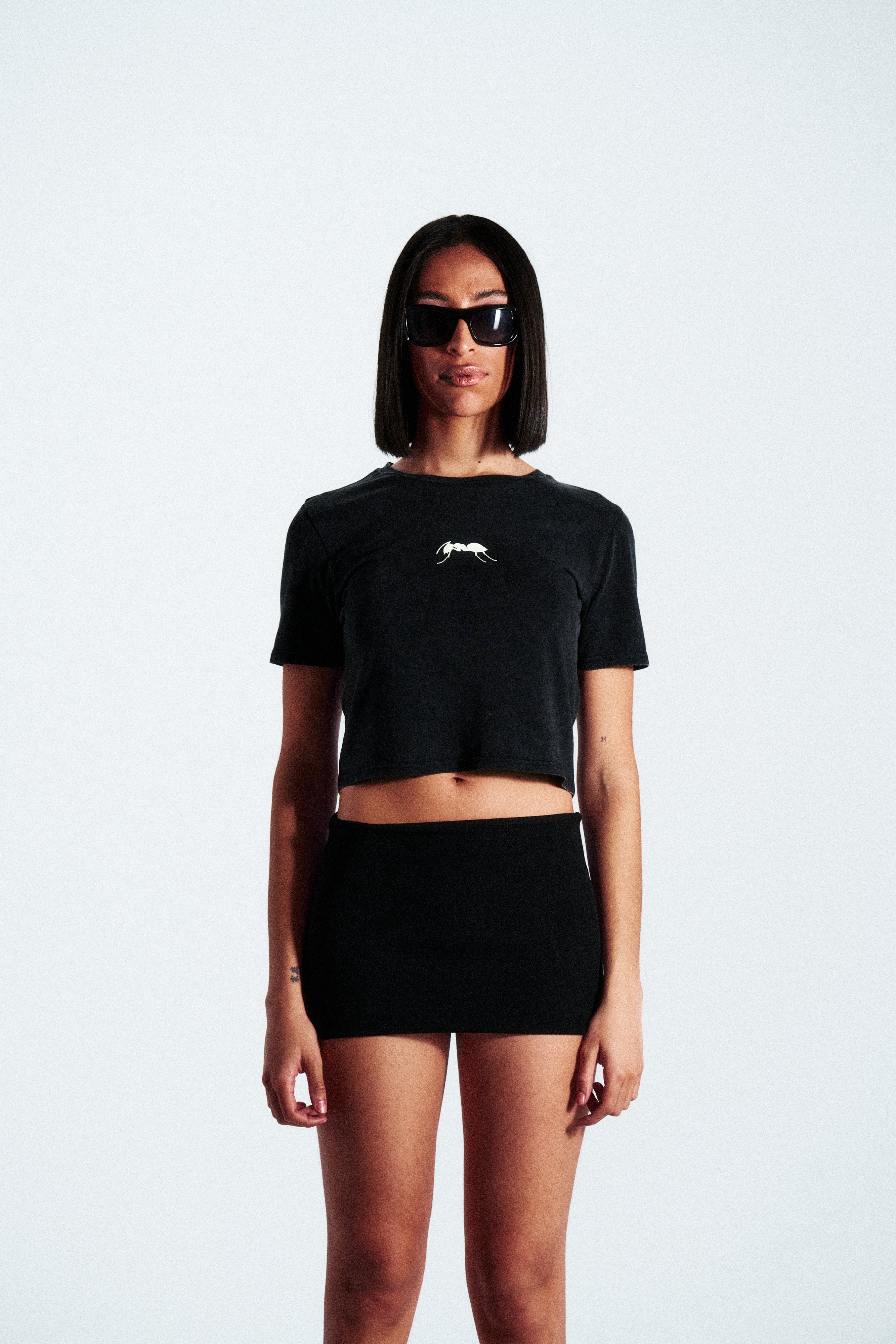 Cropped t-shirt with round neck and short sleeves. Features contrast print details on both front and back.