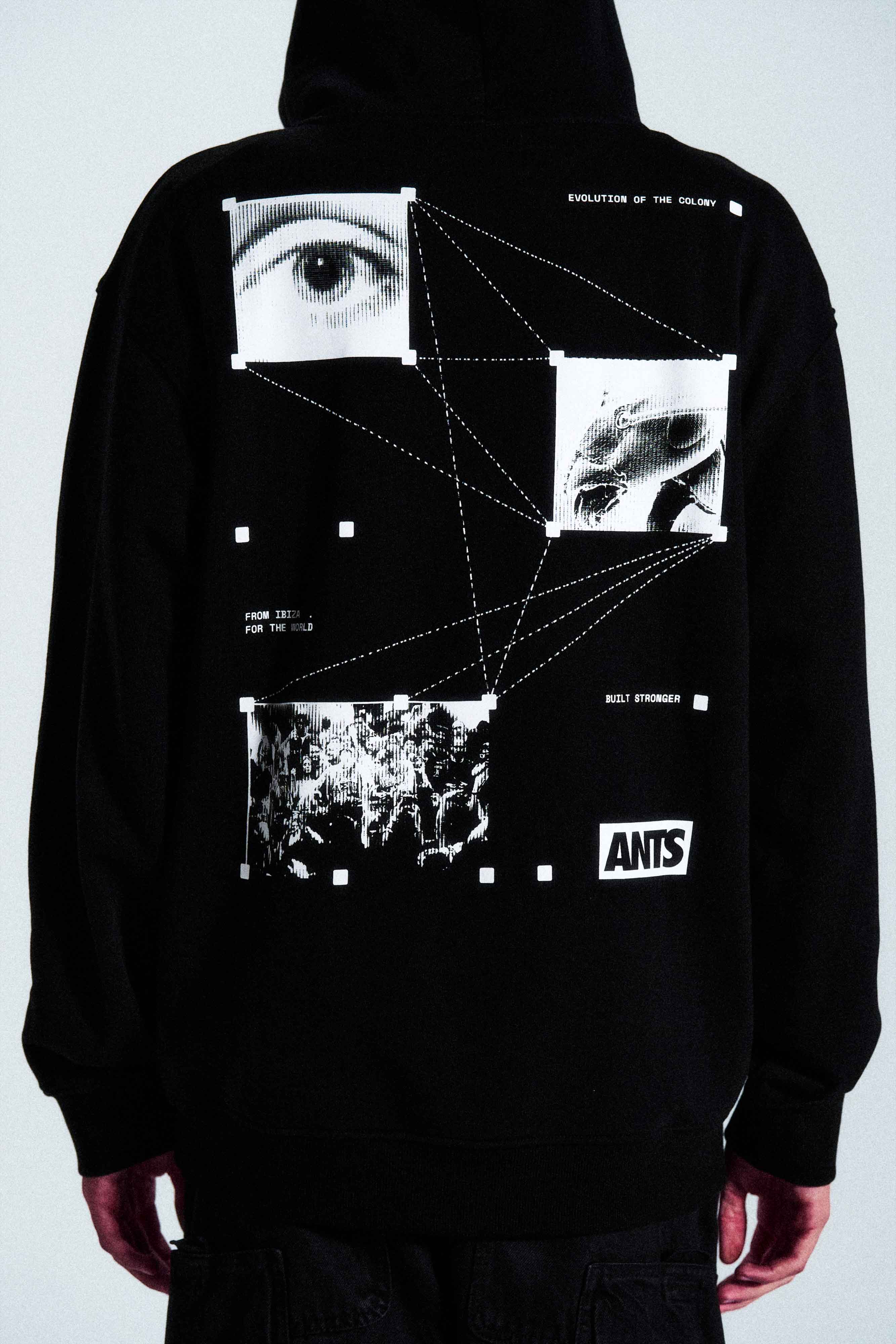 The Built Stronger Hoodie is crafted from French Terry Cotton. The black hoodie is emblazoned with a white ANTS logo on the front and features artwork on the back. A unique piece of merchandise and a versatile addition to any outfit.