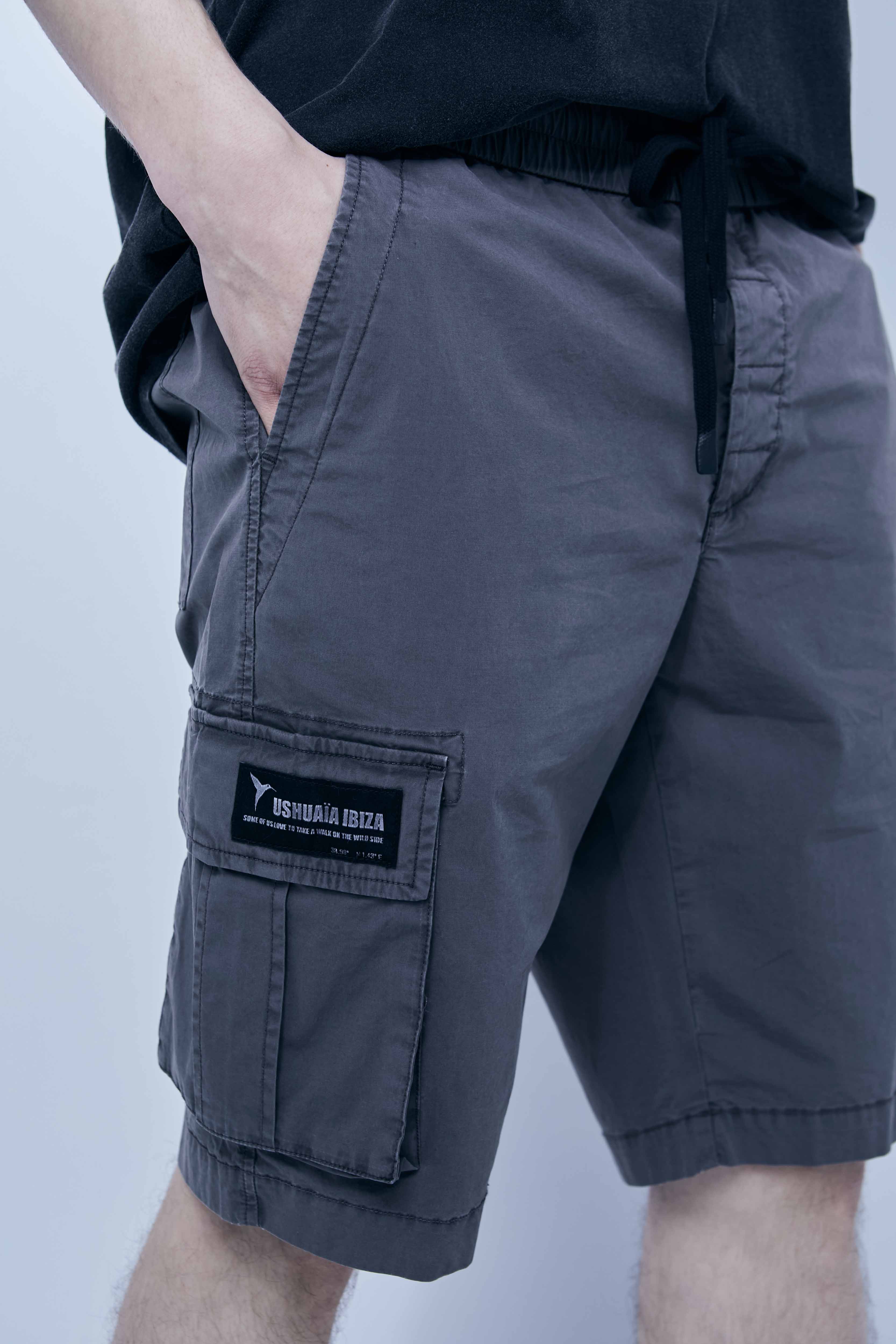 Cargo shorts made of a washed cotton blend with a fade out effect. Adjustable waistband with drawstring. Side and front cargo pockets. Rubberized patch detail on back patch pocket. Front zipper closure