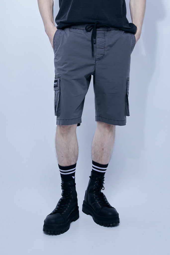 Cargo shorts made of a washed cotton blend with a fade out effect. Adjustable waistband with drawstring. Side and front cargo pockets. Rubberized patch detail on back patch pocket. Front zipper closure