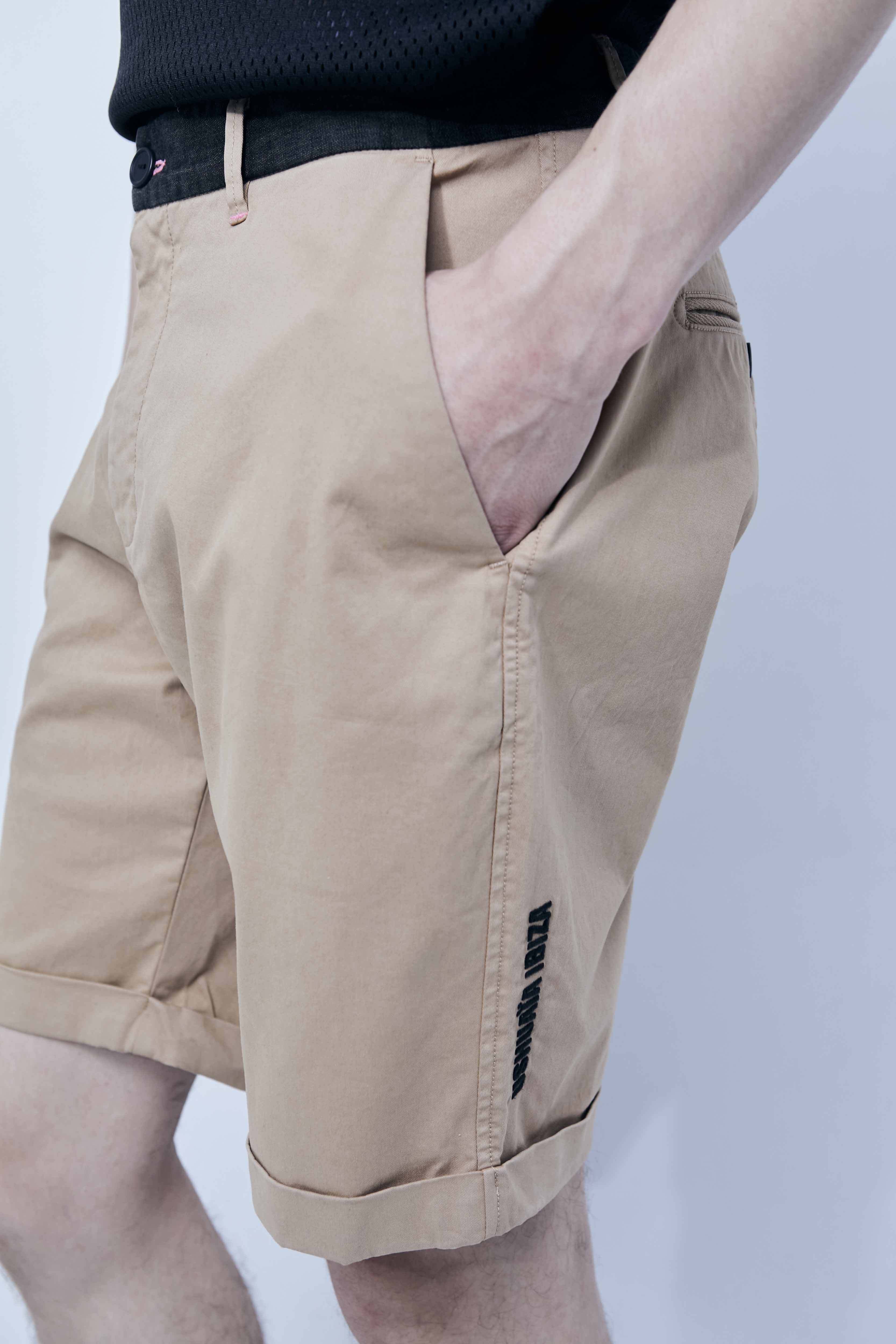 Chino shorts made of cotton-blend fabric. Contrast embroidery on the front and side. Decorative stitching detail and contrast waistband. Front pockets and back welt pockets. Front zipper and button closure