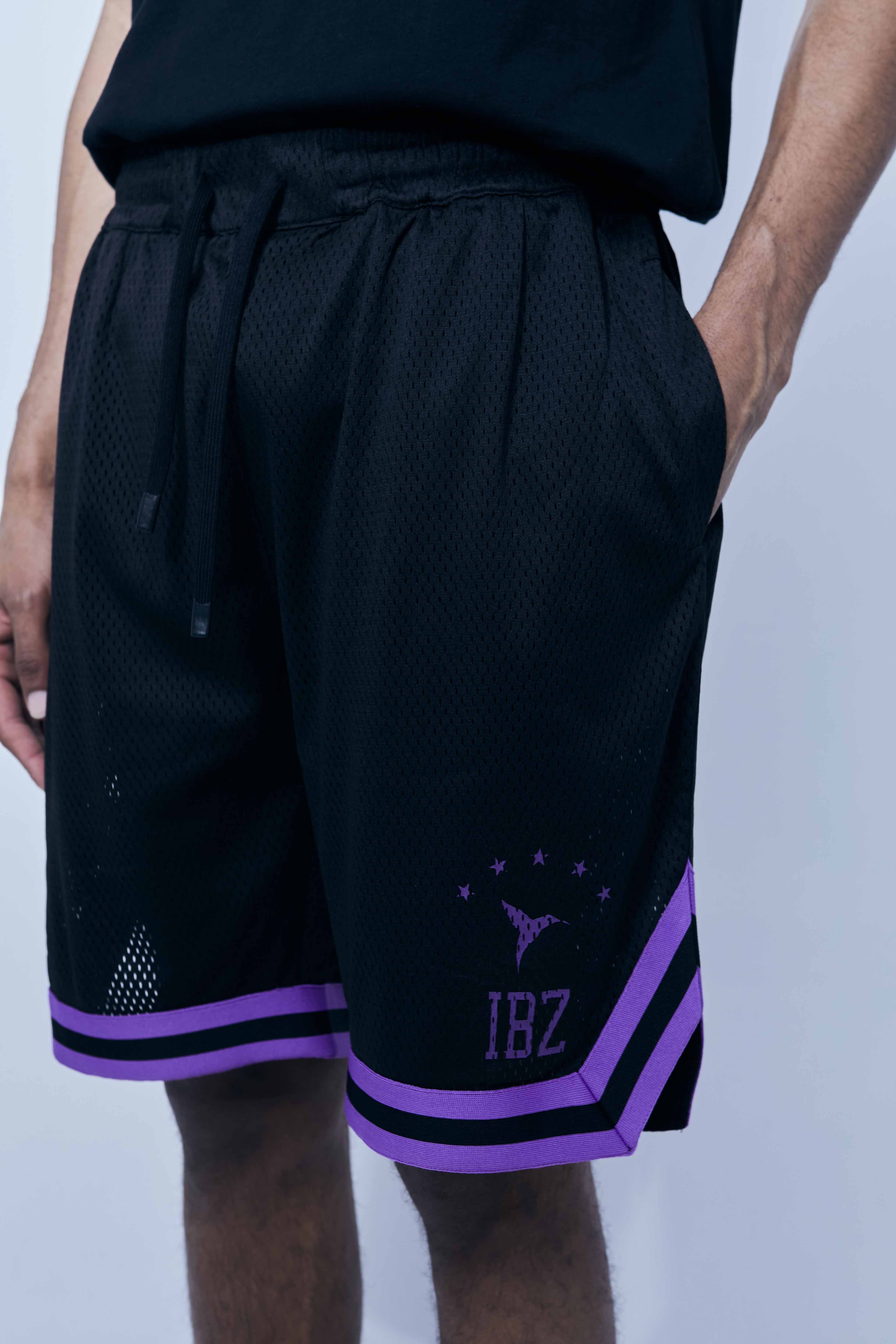 Wide Bermuda shorts made of mesh fabric with an open and elastic structure. Adjustable elastic waist inside. Laces with rubberized ends. Printing detail on the front. Side hip pockets. 