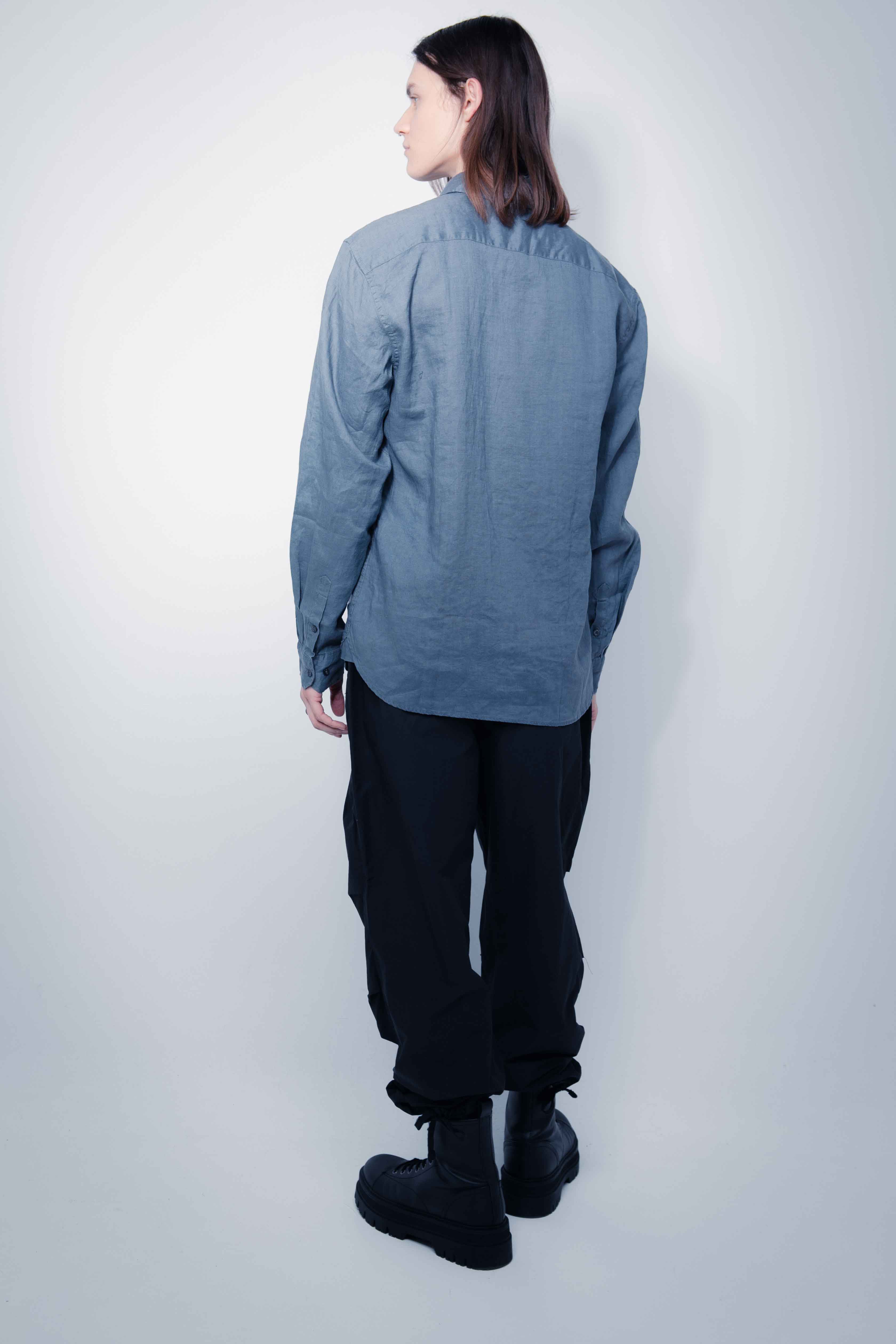 Shirt made of linen fabric. Lapel collar and long sleeves with button cuffs. Front button closure