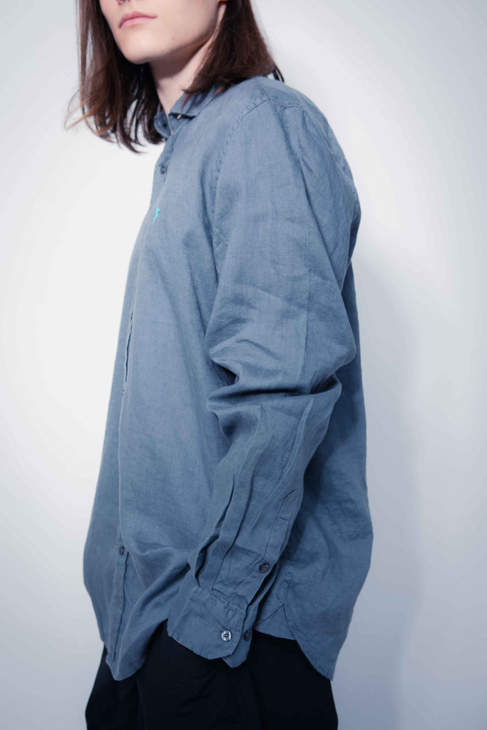 Shirt made of linen fabric. Lapel collar and long sleeves with button cuffs. Front button closure