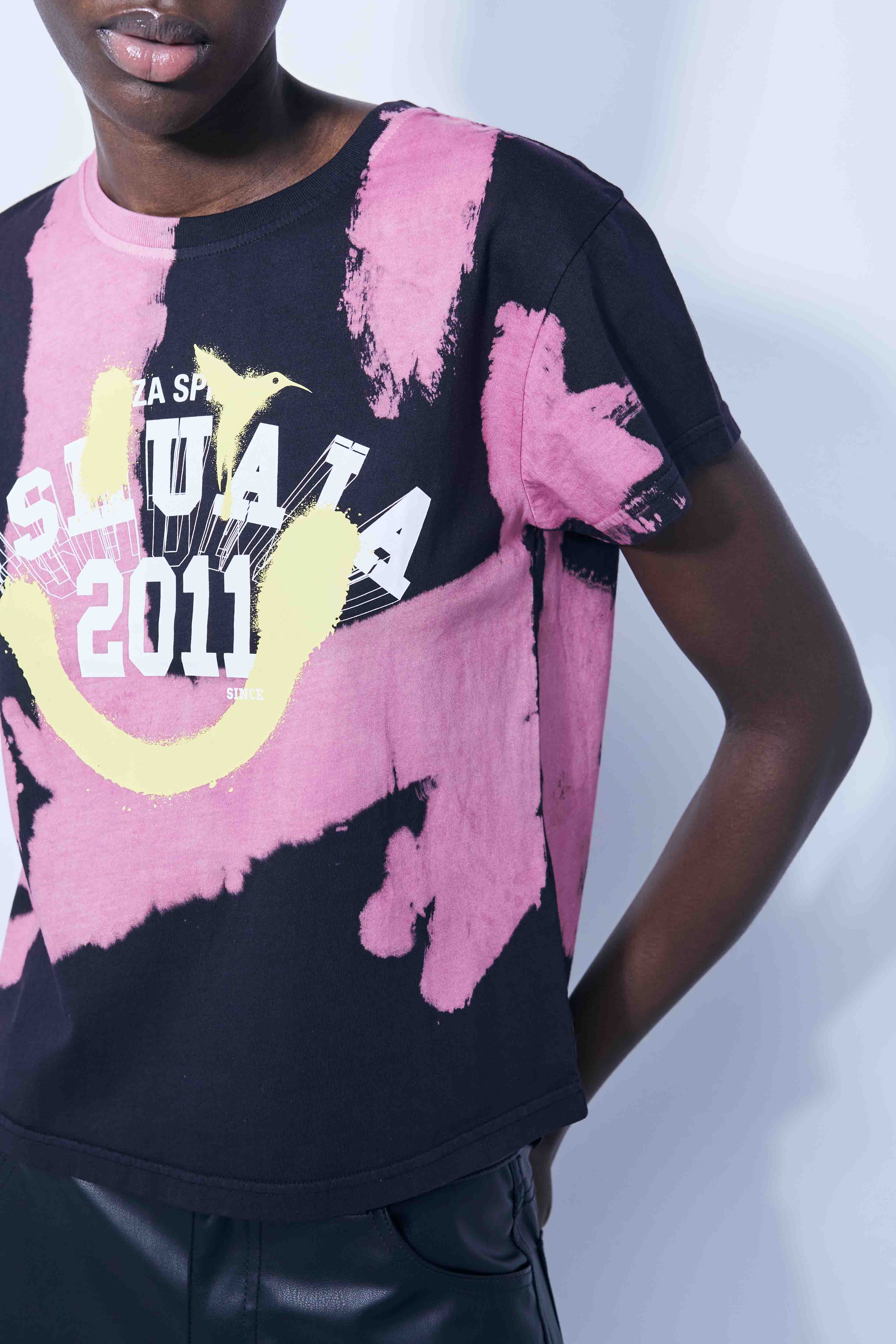 Pink tie-dye T-shirt with bold black logo print – Ushuaïa Ibiza streetwear essential.