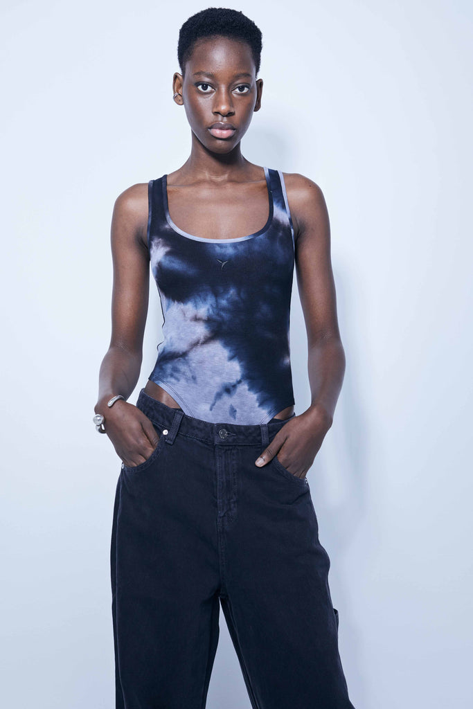 Washed rib bodysuit with tie-dye effect. Round neckline and straps. Embroidery detail on the front. Bottom closure with snap buttons.