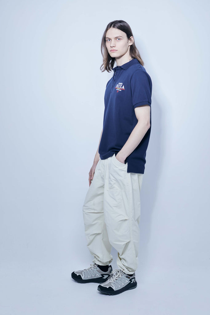 Polo made of cotton fabric with a mercerized finish. Lapel collar with front button closure and short sleeves. Embroidered application detail on the front