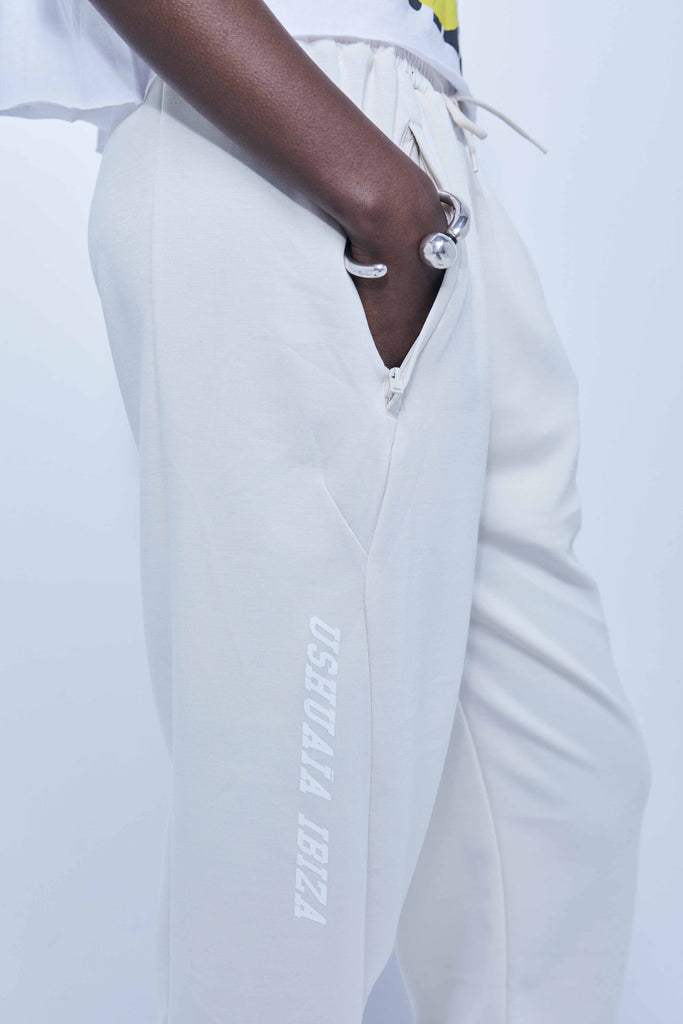 Pants with elastic waist with drawstring and integrated pockets. Hem finished with elastic cuff. Rubberized print detail on the front