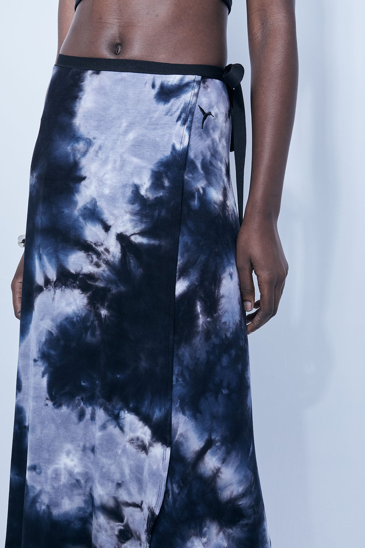 Wrap skirt in soft ribbed viscose with tie-dye effect. Embroidered detail on the front. Crossover design.