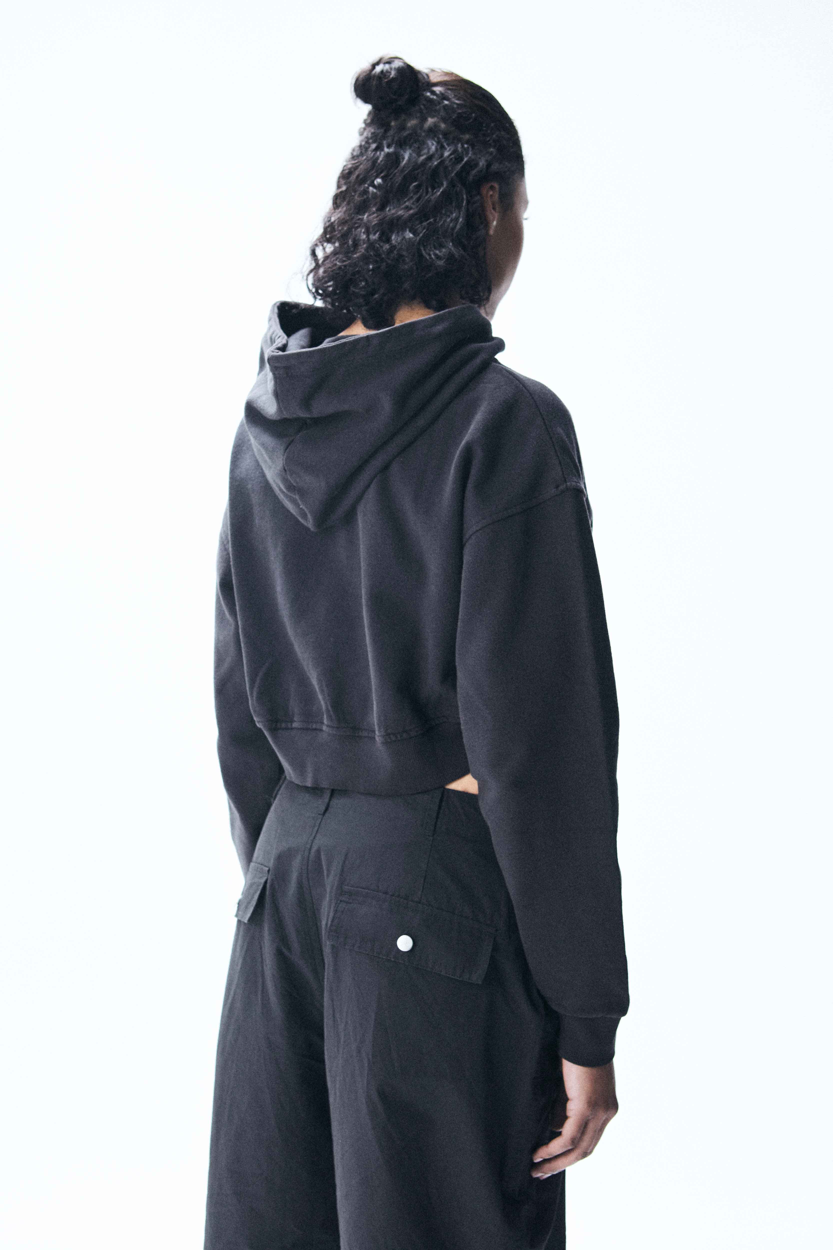 Cropped hoodie with long sleeves and faded wash effect. Front graphic print with contrasting details.