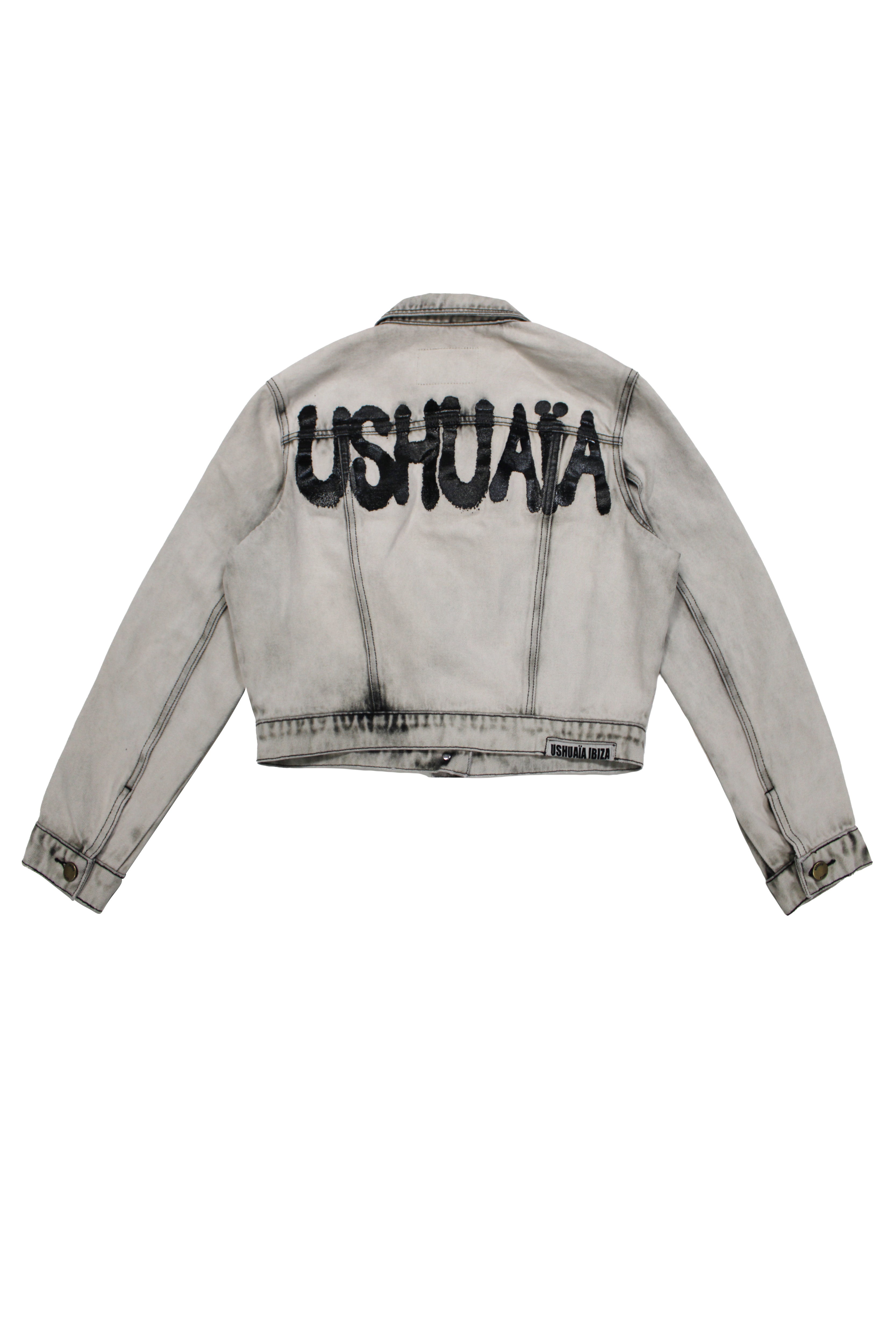 Cropped denim jacket with lapel collar and long sleeves, washed with a fade-out effect. Front closure with metal buttons. Features embroidery detail on the front and contrast combined print on the back. 