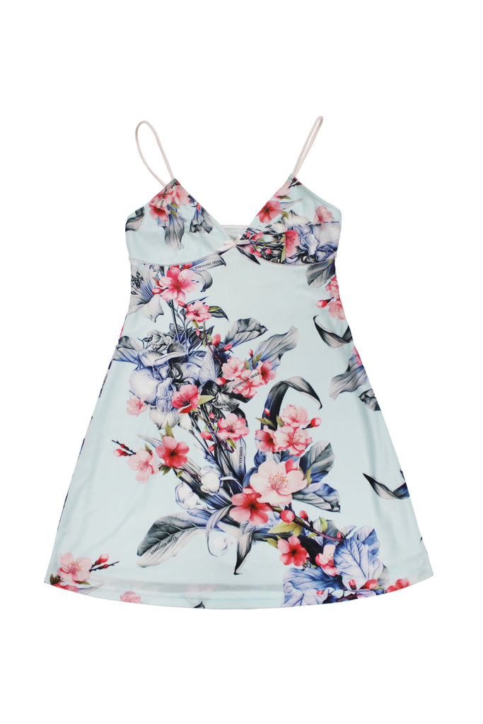 Elastic printed slip dress with lining. Adjustable straps. Bow detail with metallic ornament on neckline and hem opening. 