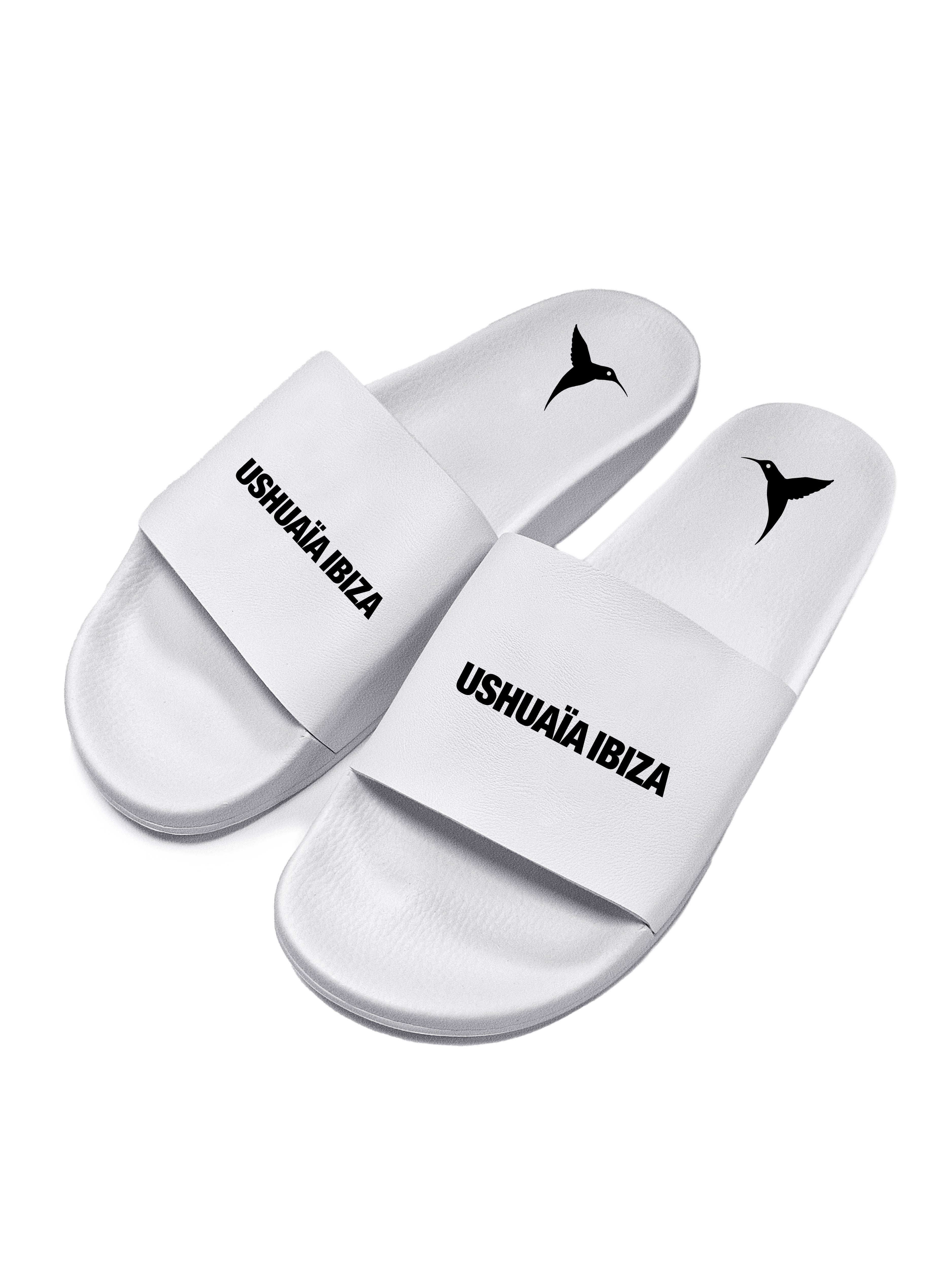 White flip flops with black logo.Polyurethane sole with cotton and polyester lining.Screen printing and engraving in high frecuency.
