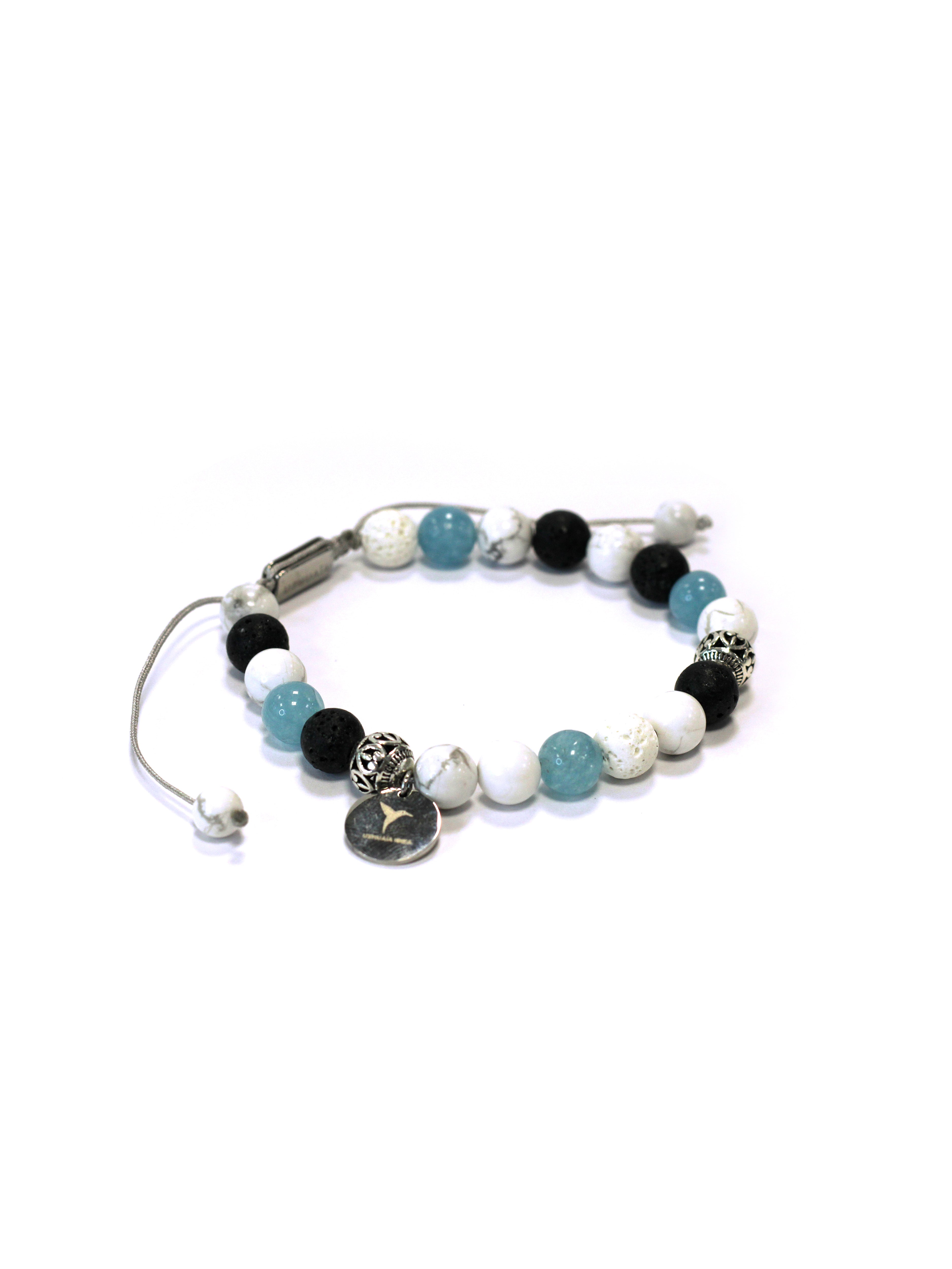 Adjustable bracelet with textile cord. Round beads in white, black, and blue tones, with metallic details. Circular metal charm with engraved logo. Unisex design.
COMPOSITION:
natural stone, resin, metal alloy, textile cord.
 