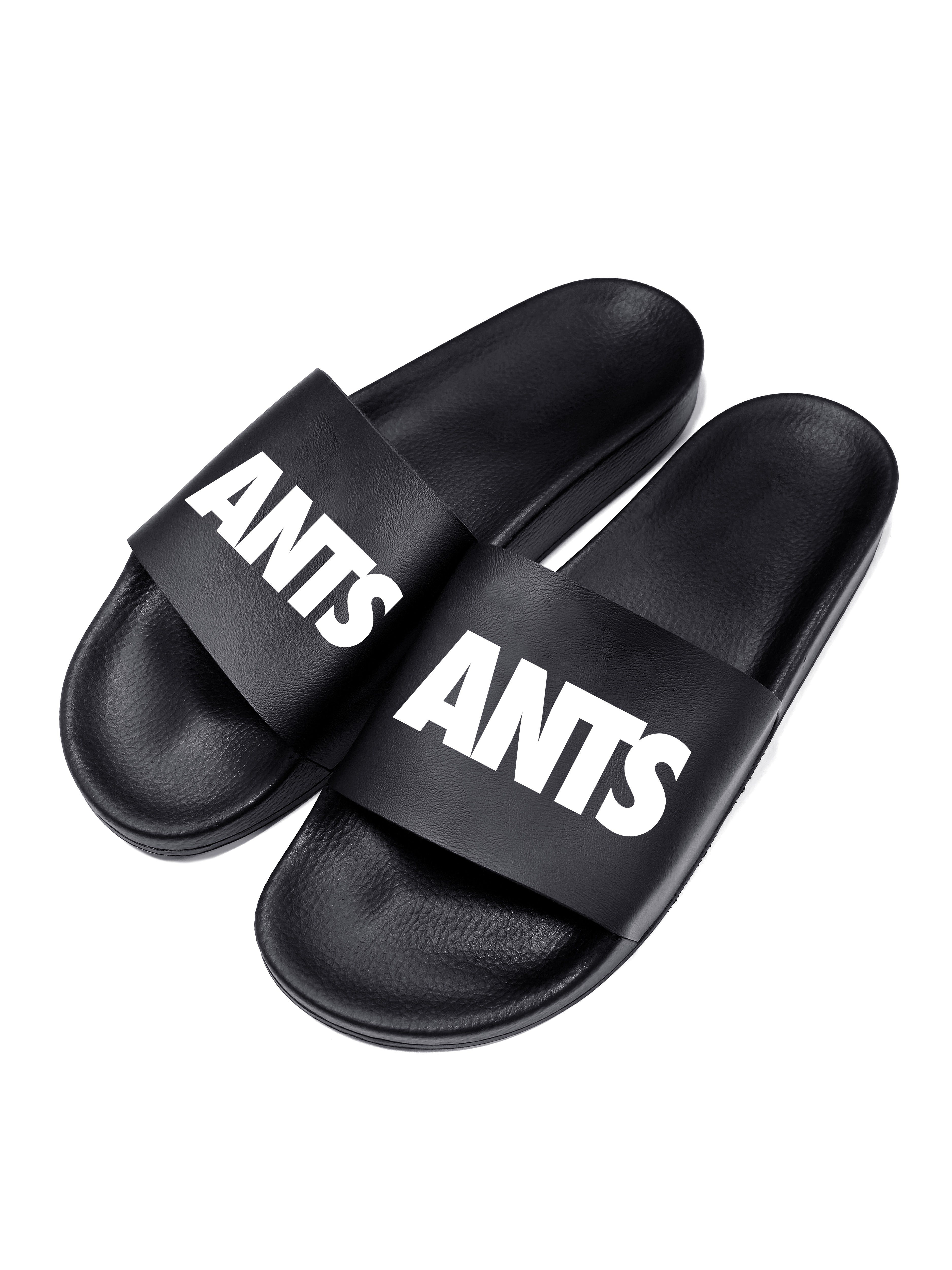 Black flip flops with white logo. Polyurethane sole with cotton and polyester lining. Comfortable, durable design with high-definition graphic detail.