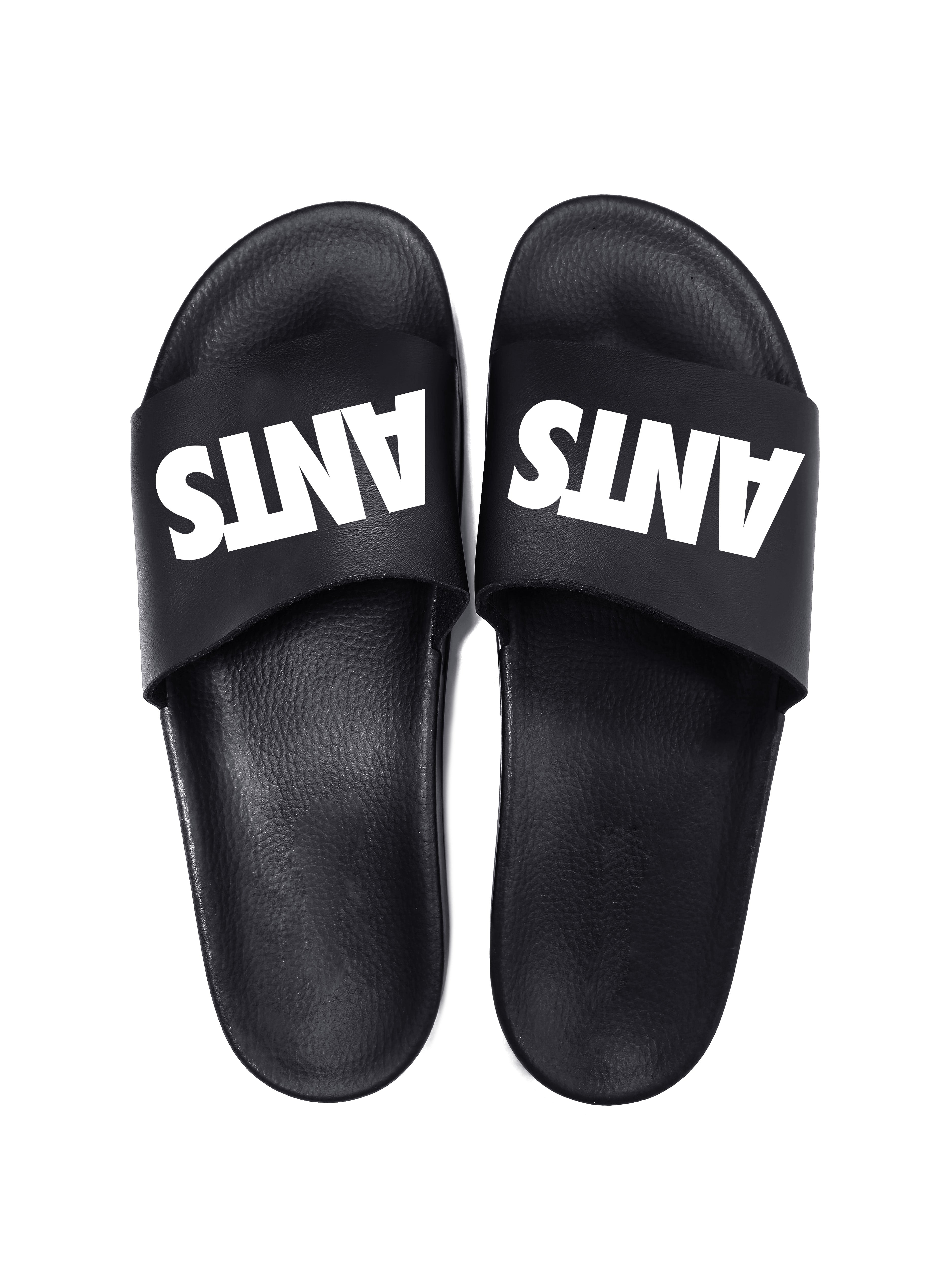 Black flip flops with white logo. Polyurethane sole with cotton and polyester lining. Comfortable, durable design with high-definition graphic detail.