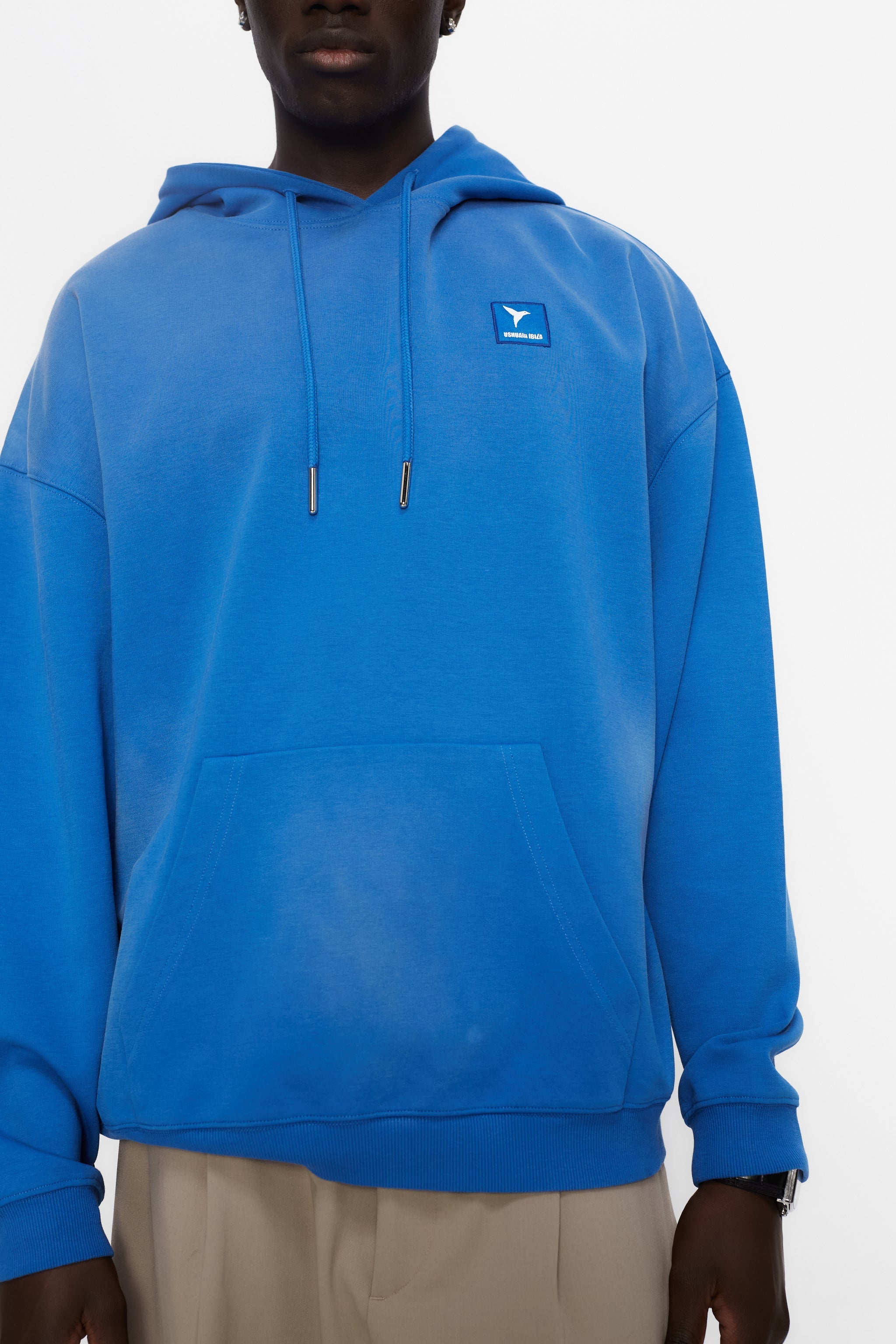 Oversized sweatshirt with adjustable hood with drawstring and long sleeves washed with enzymatic effect. Contrast combined patch detail on the front and print on the back. Kangaroo pocket on the front. Ribbed finishes.  
