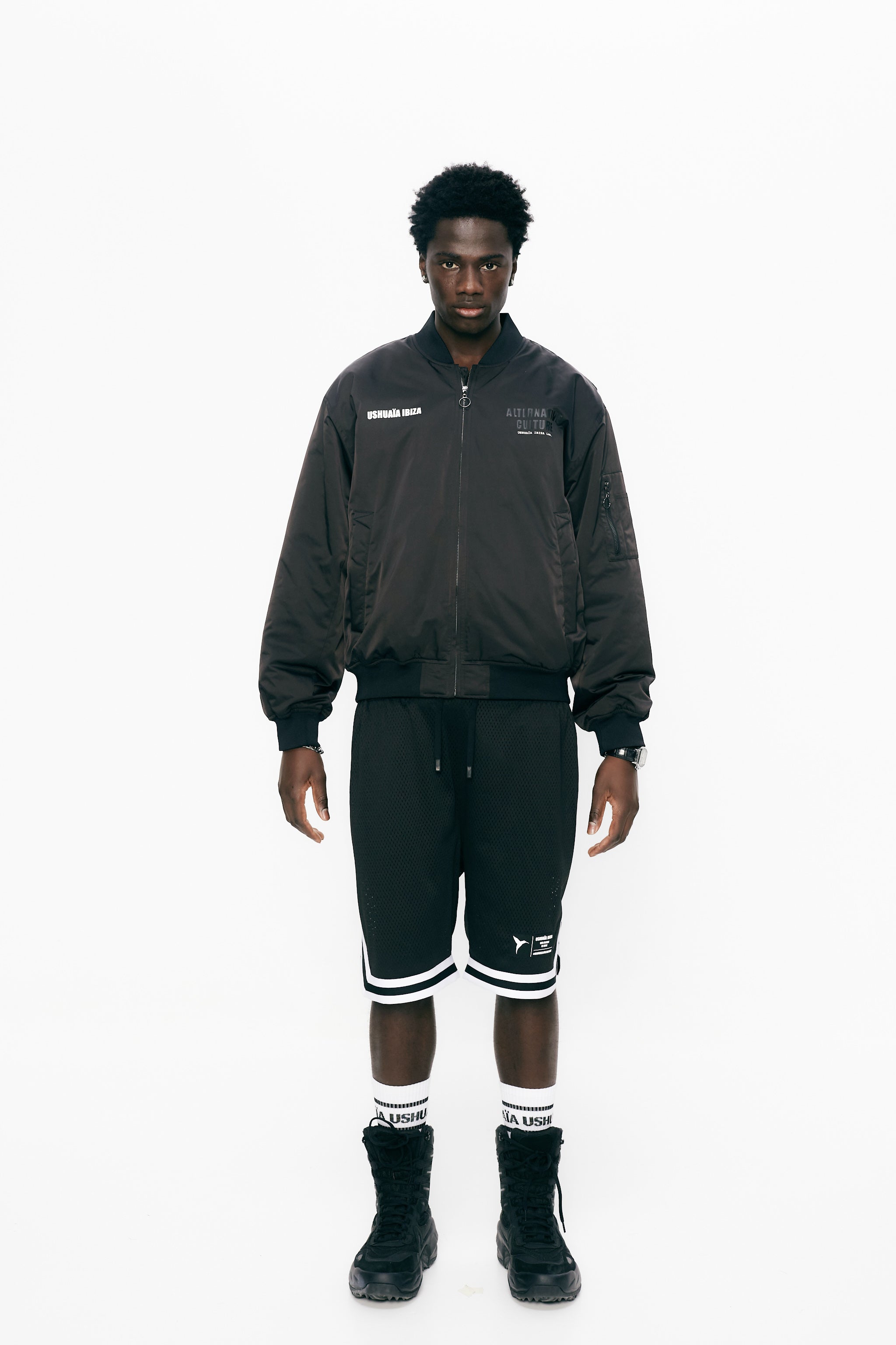 Satin bomber jacket with elastic collar and long sleeves. Rubber print detail on the front and fabric and embroidery application on the back. Front welt pockets. Sleeve pocket with custom puller. Front closure with two-way zipper. Ribbed finishes.