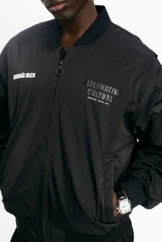 Satin bomber jacket with elastic collar and long sleeves. Rubber print detail on the front and fabric and embroidery application on the back. Front welt pockets. Sleeve pocket with custom puller. Front closure with two-way zipper. Ribbed finishes.