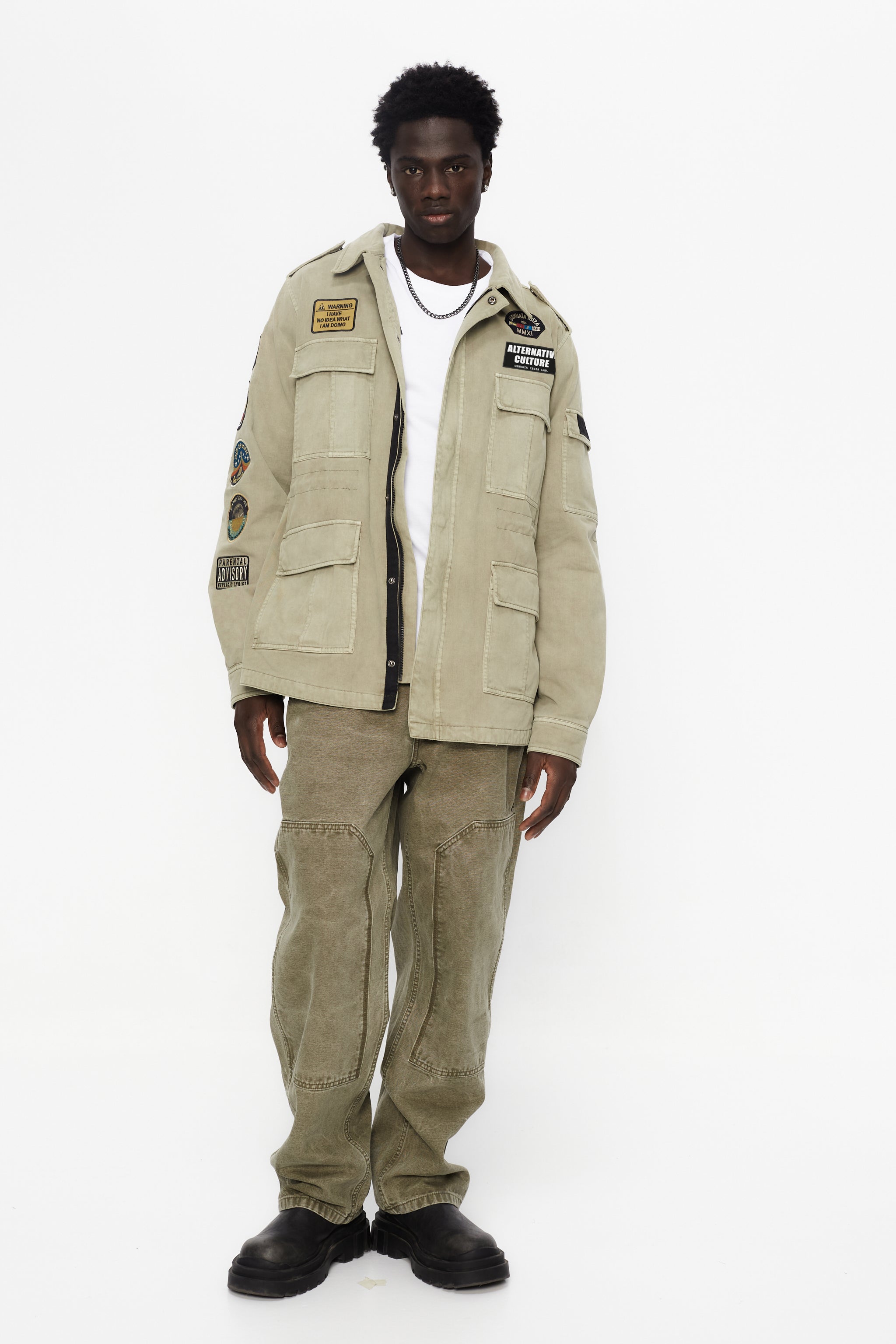 Washed twill military jacket with shirt collar and long sleeves with adjustable cuff with button. Central zip closure with adjustable drawstring at the waist. Patch pockets and flap on the front and sleeve. Combination of patches and embroidered application on front and back. Custom label detail on the back.