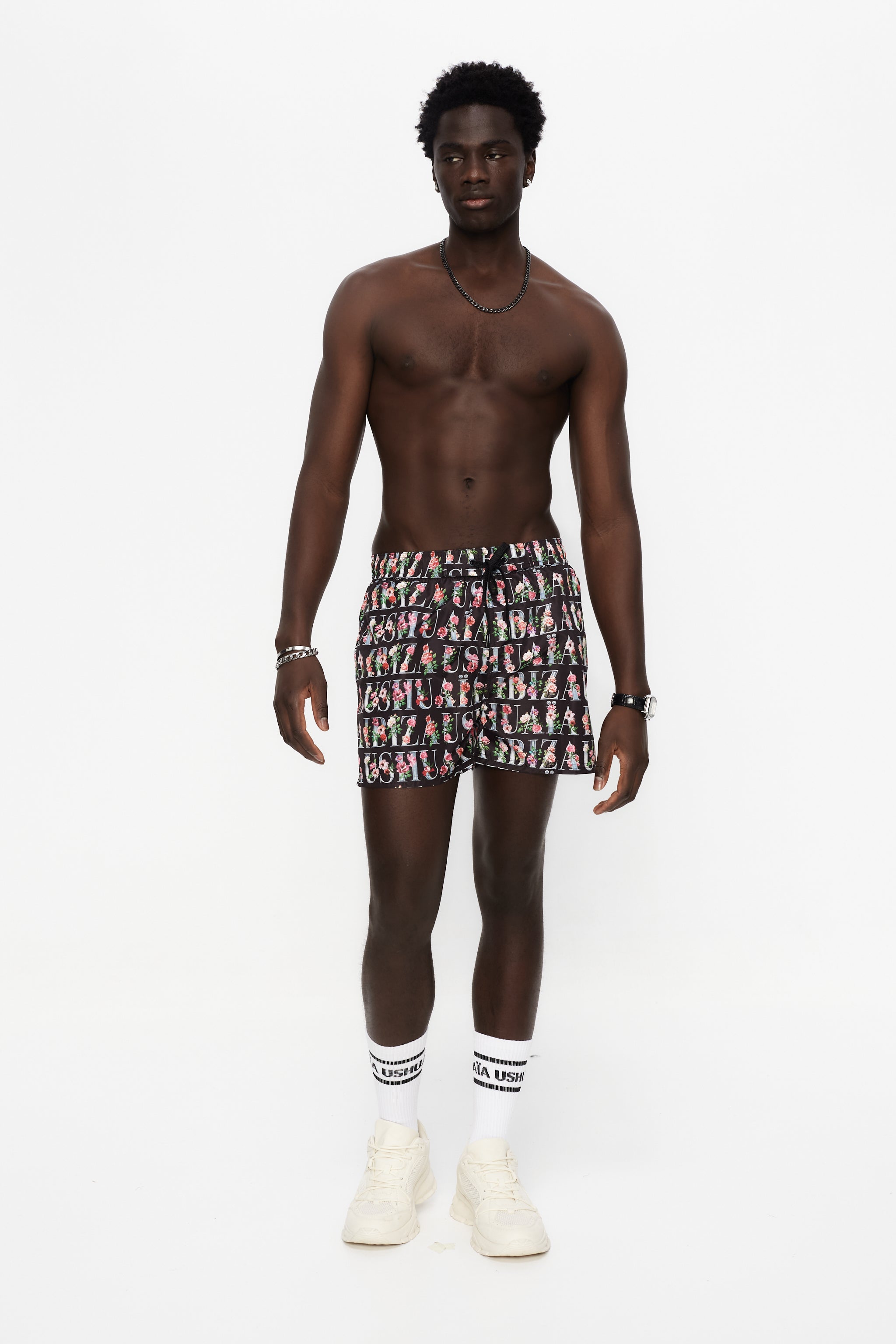 Swimsuit made of technical fabric. Adjustable elastic waistband with drawstring. Side pockets, rubberized application detail on the front and patch pocket on the back. Inner lining.